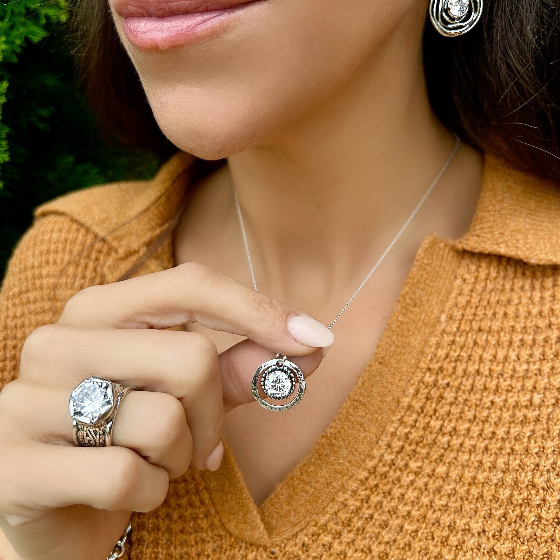 round sterling silver necklace pendant with an inner ring holding a prong-set cz stone