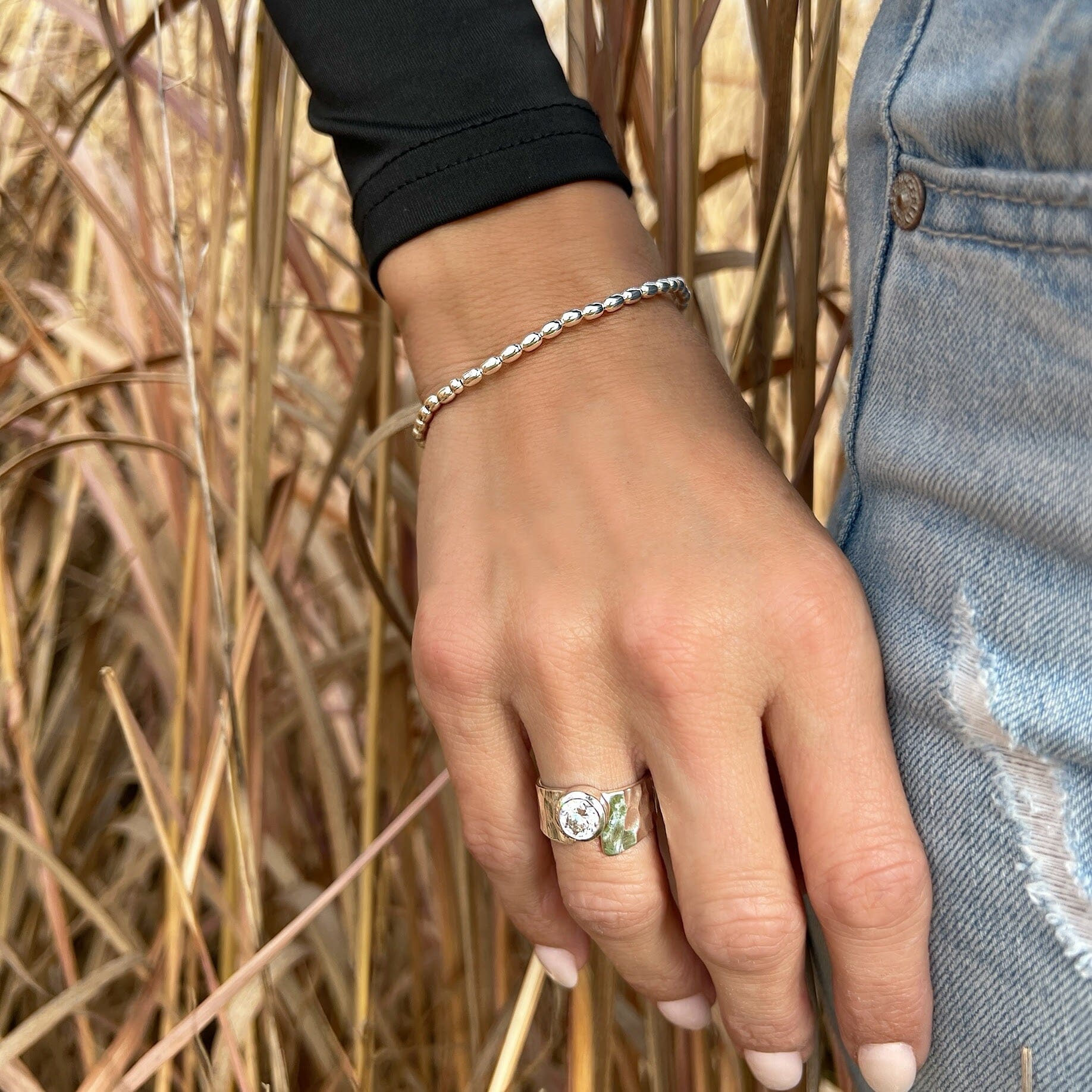 minimalist style stretch bracelet featuring silver oval shaped beads