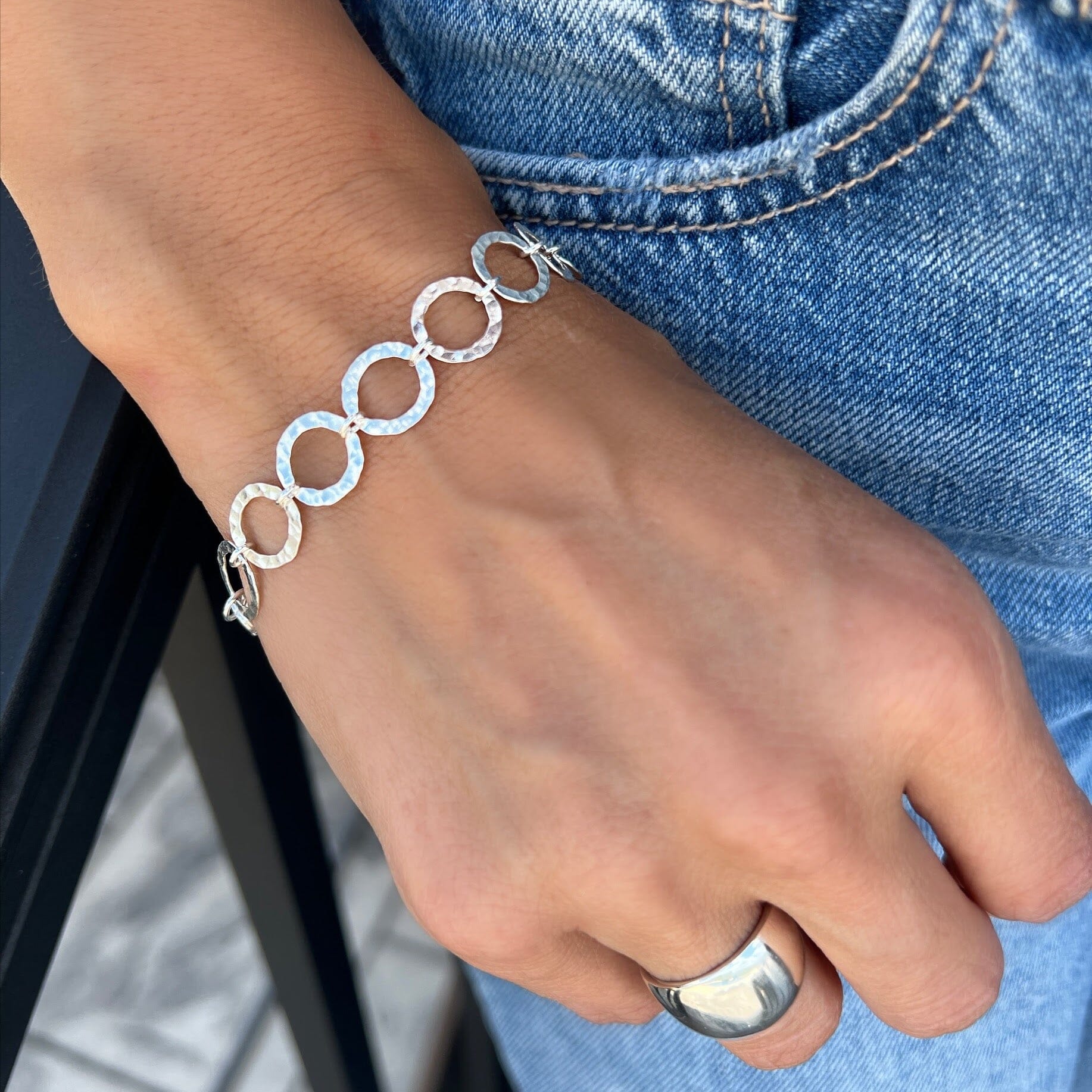 bracelet with open disks linked together with a hammered silver finish