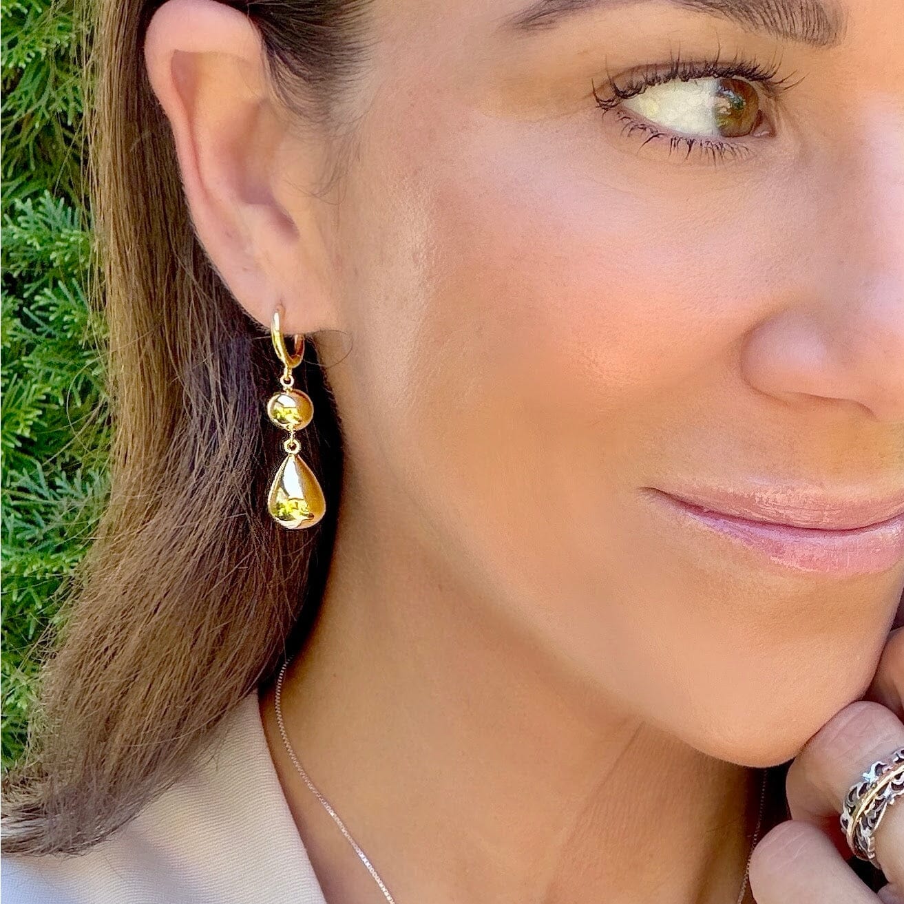 gold huggie style earrings featuring two beaded dangles