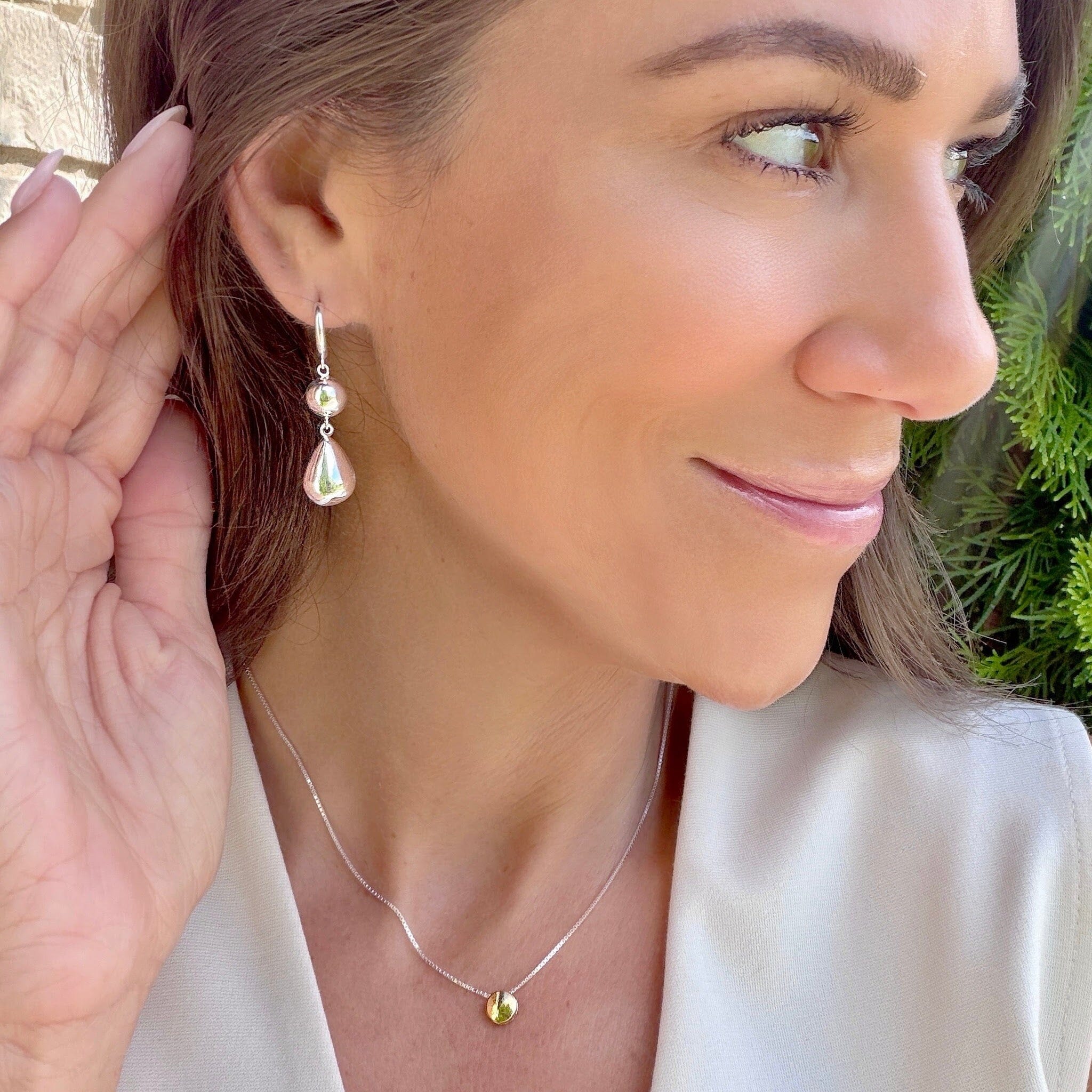 silver huggie style earrings featuring two beaded dangles