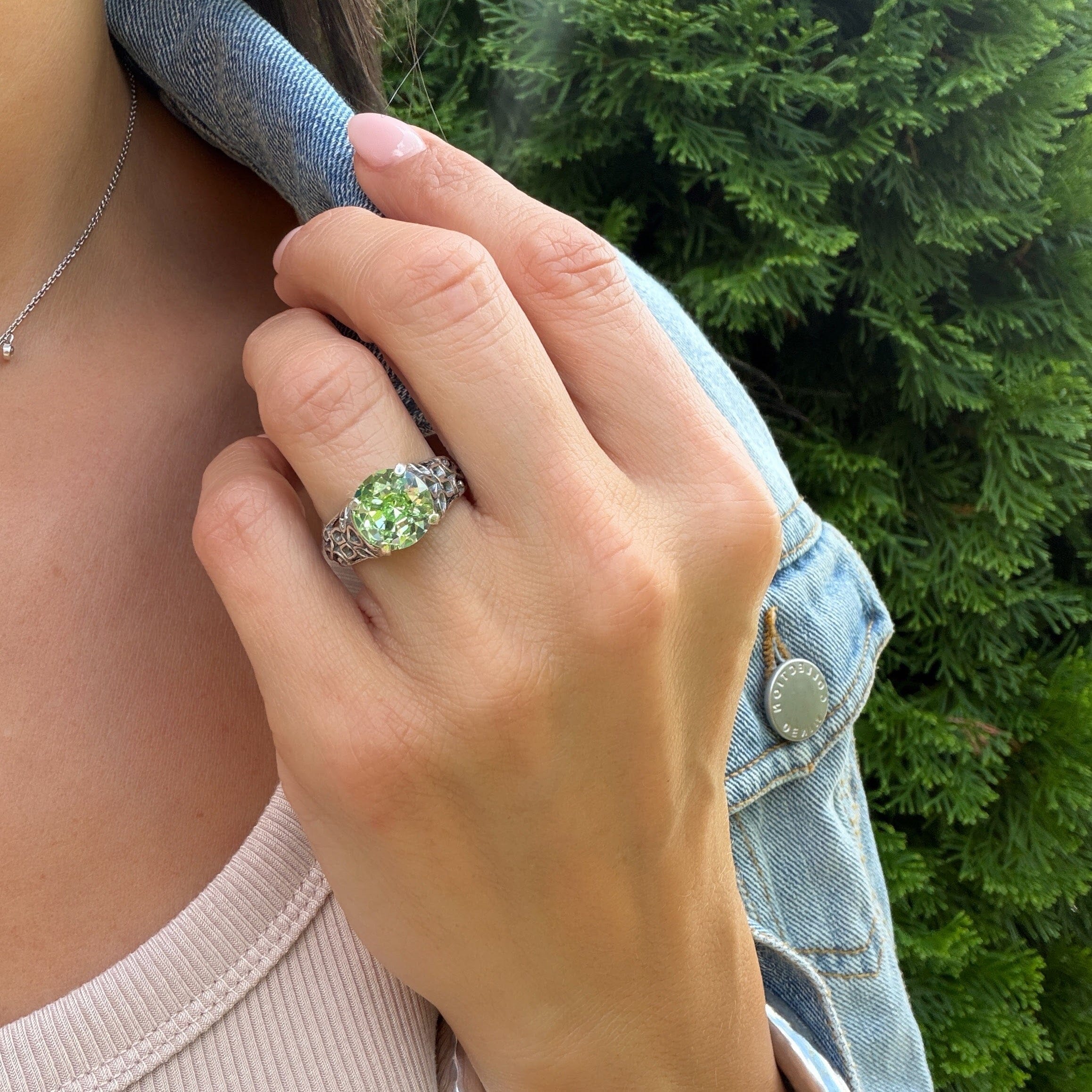 sterling silver ring featuring prong-set green crystal