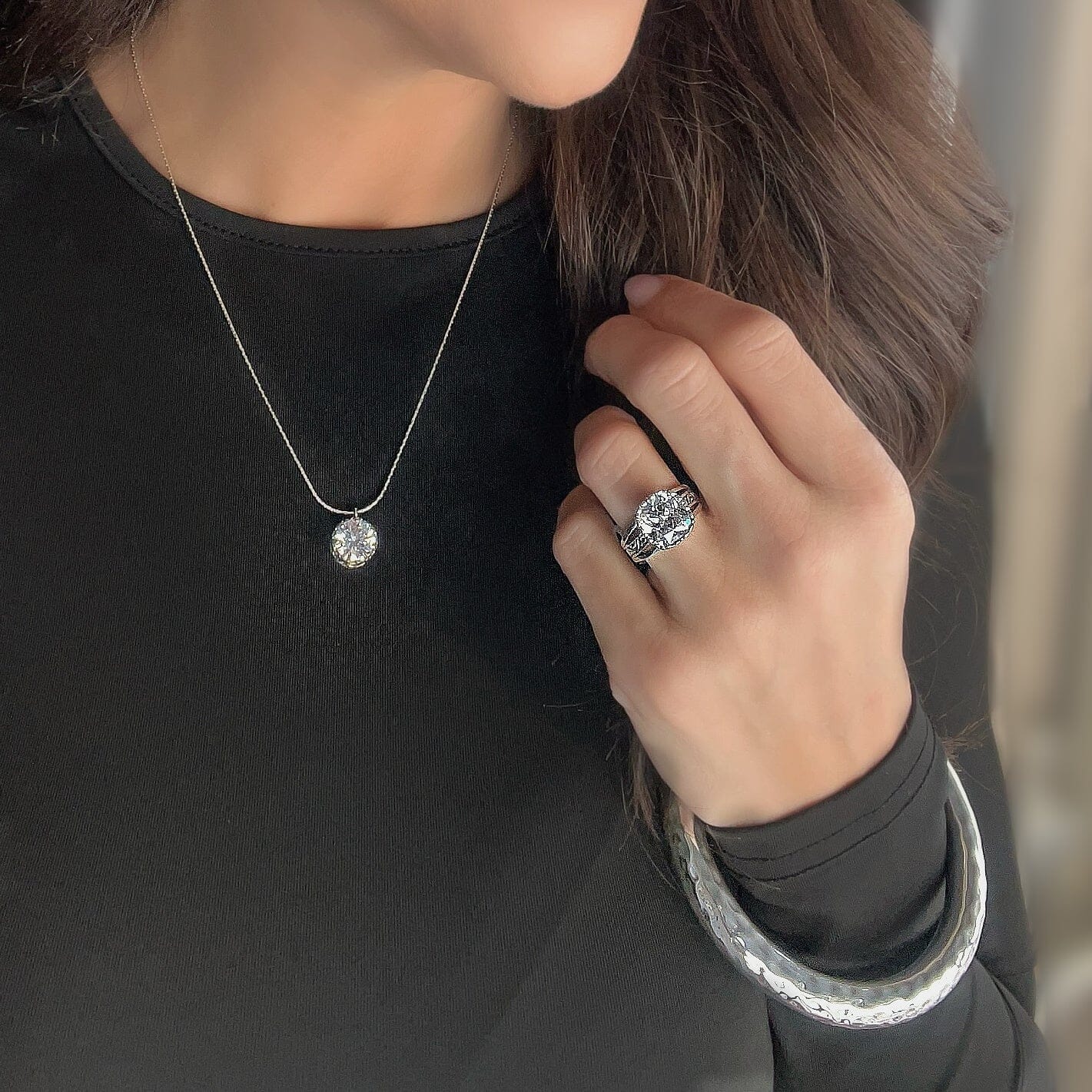 sterling silver ring featuring a CZ stone prong set with a raised design on the band. paired with the Jackie-O necklace and hammered bliss bangle