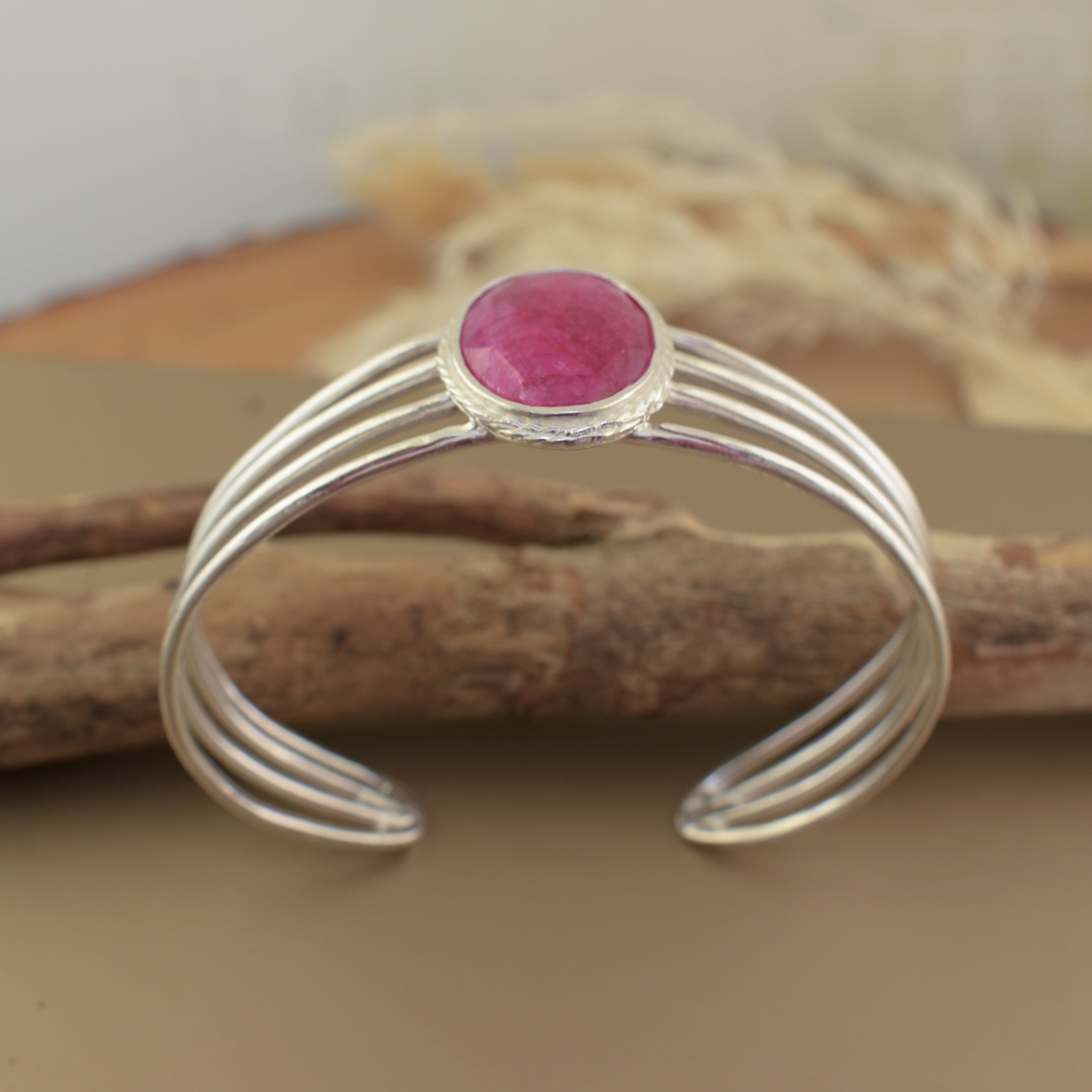 Handcrafted sterling silver cuff bangle featuring oval dyed ruby stone