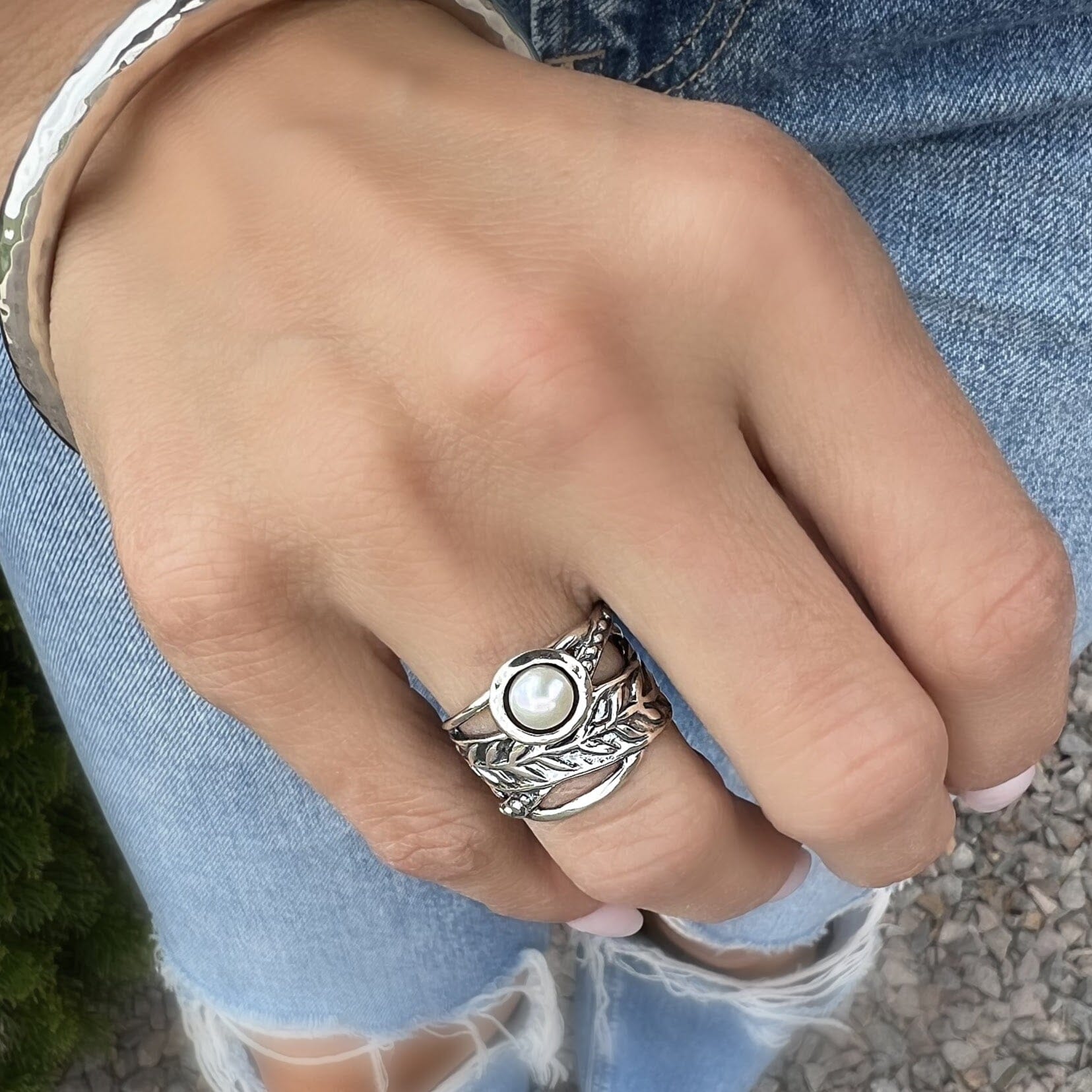 silver designer ring featuring vine details and a pearl center