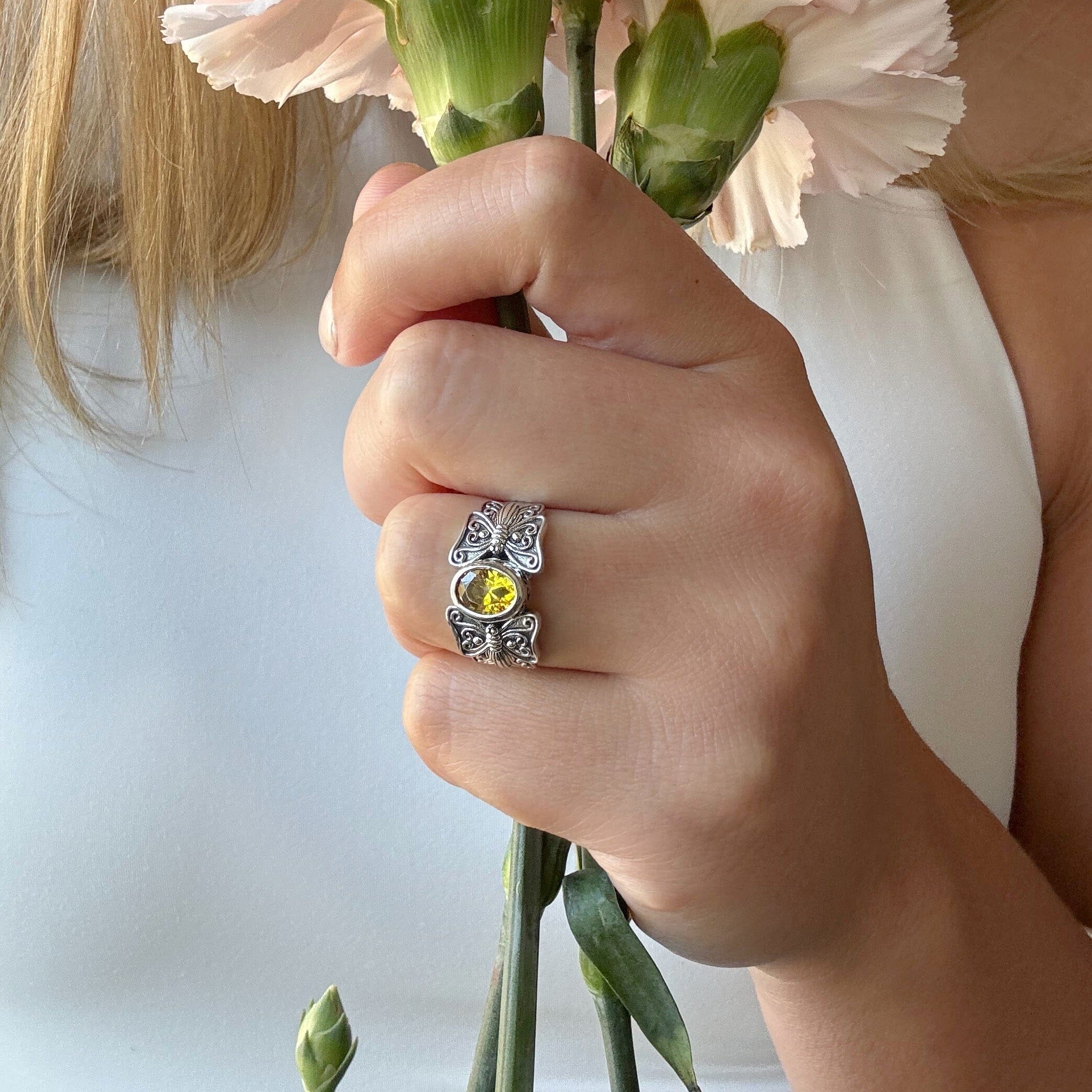 silver butterfly ring featuring an oval citrine stone
