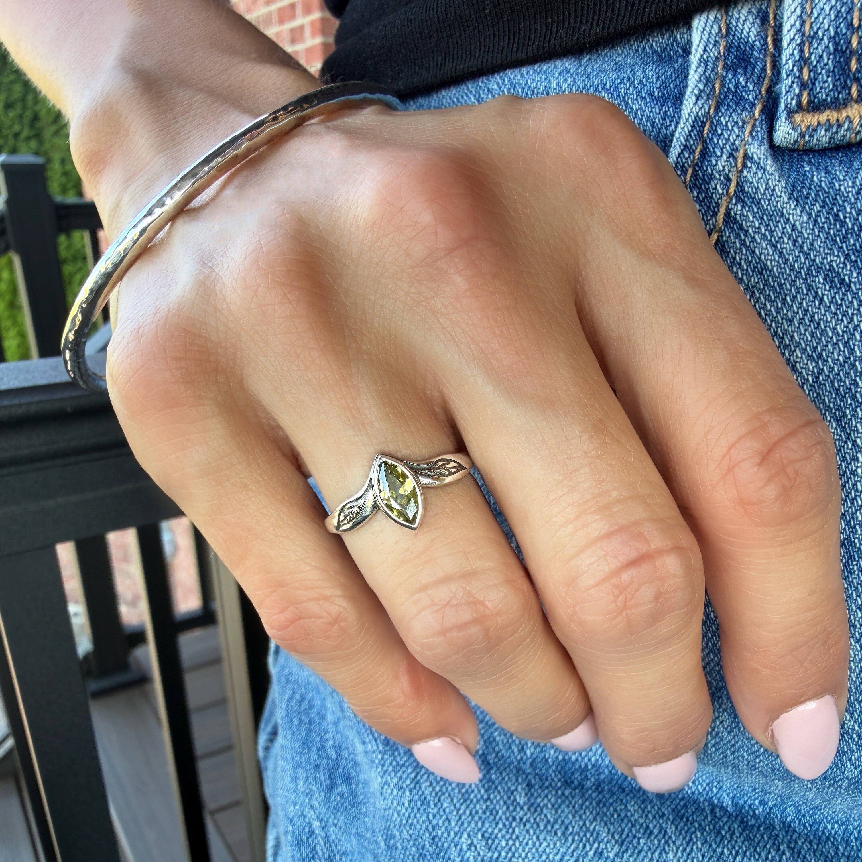 sterling silver ring with an olive colored CZ center stone