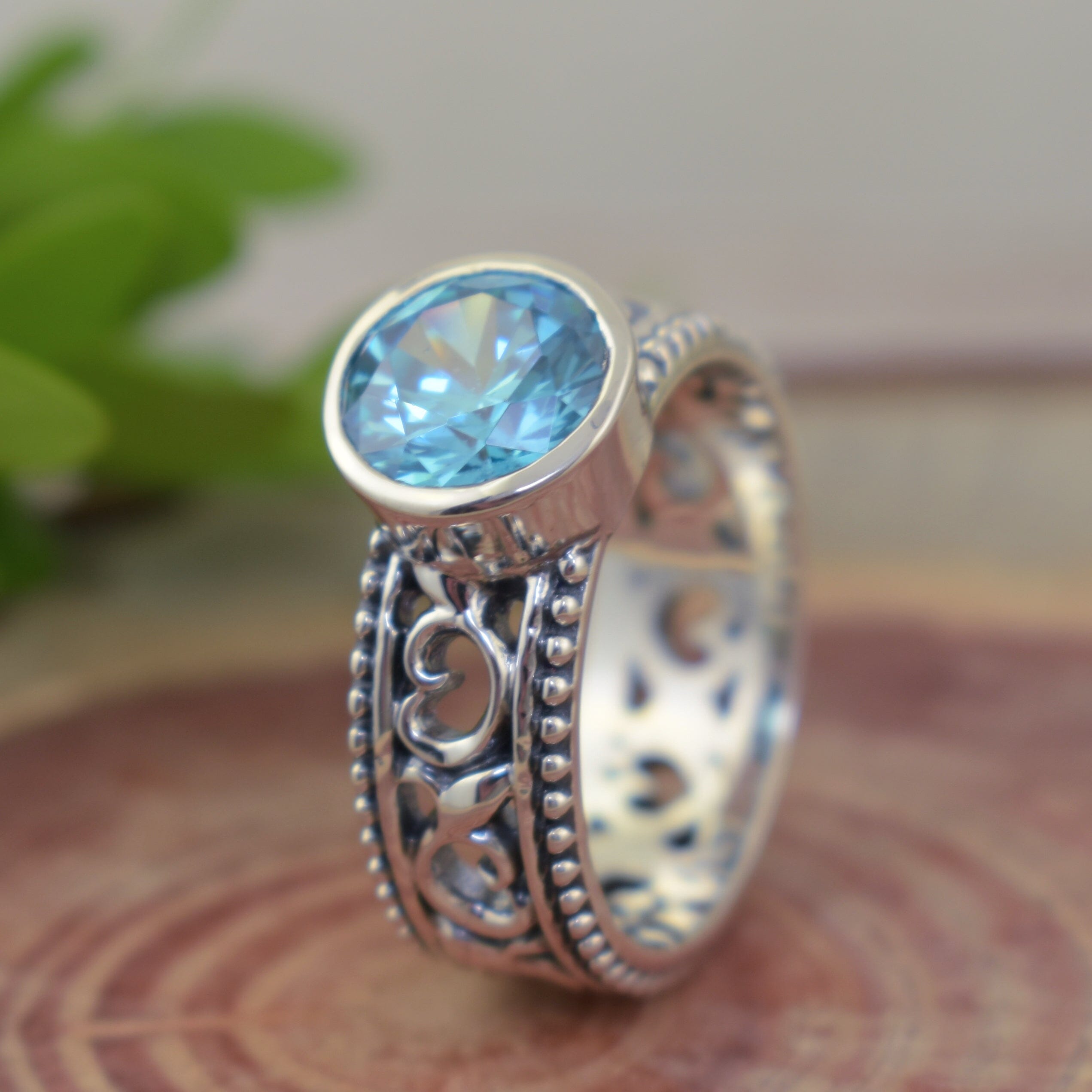 Intricate detail sterling silver band featuring swirls and beaded border and blue aquamarine stone
