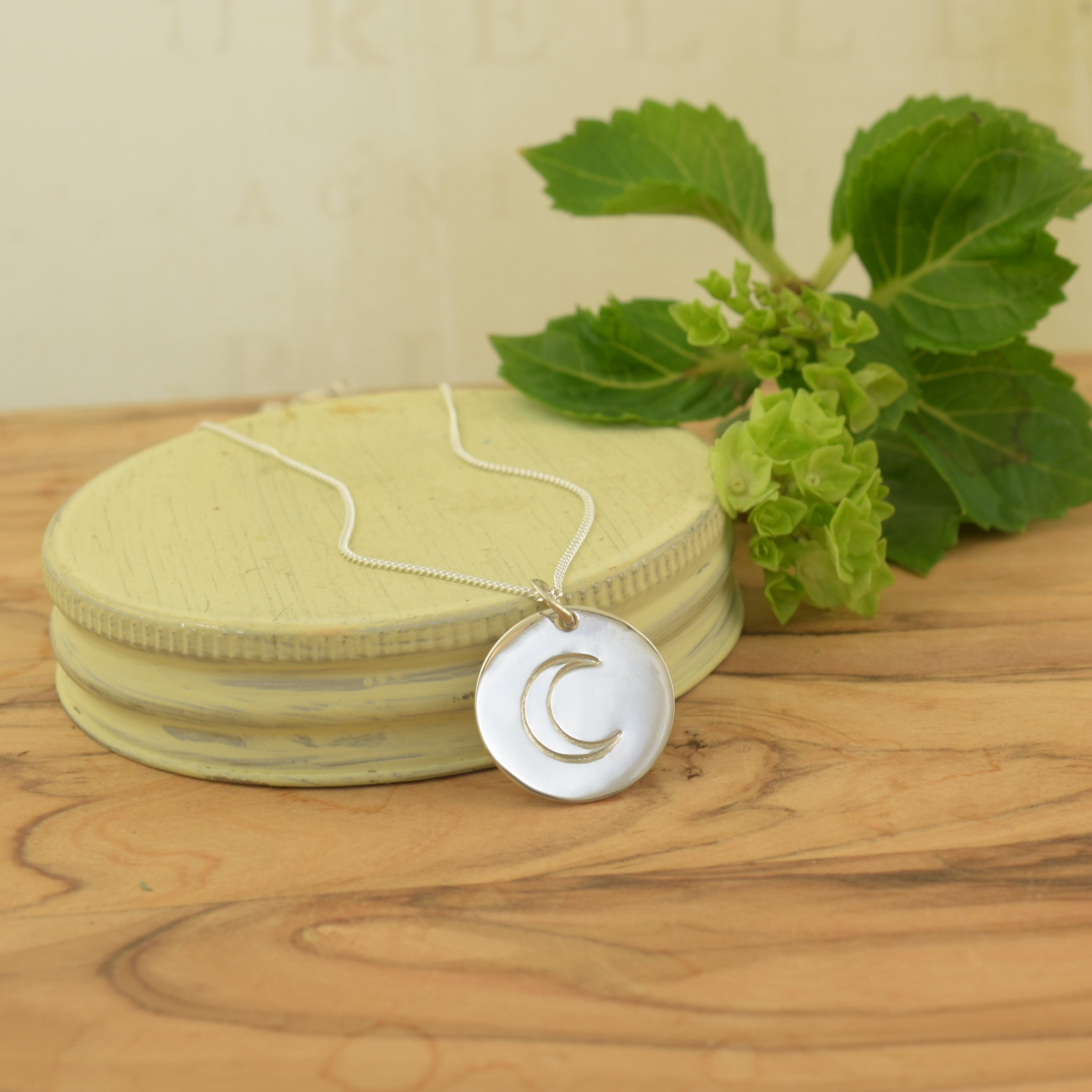 High polished sterling silver rounded pendant featuring half moon style stamp