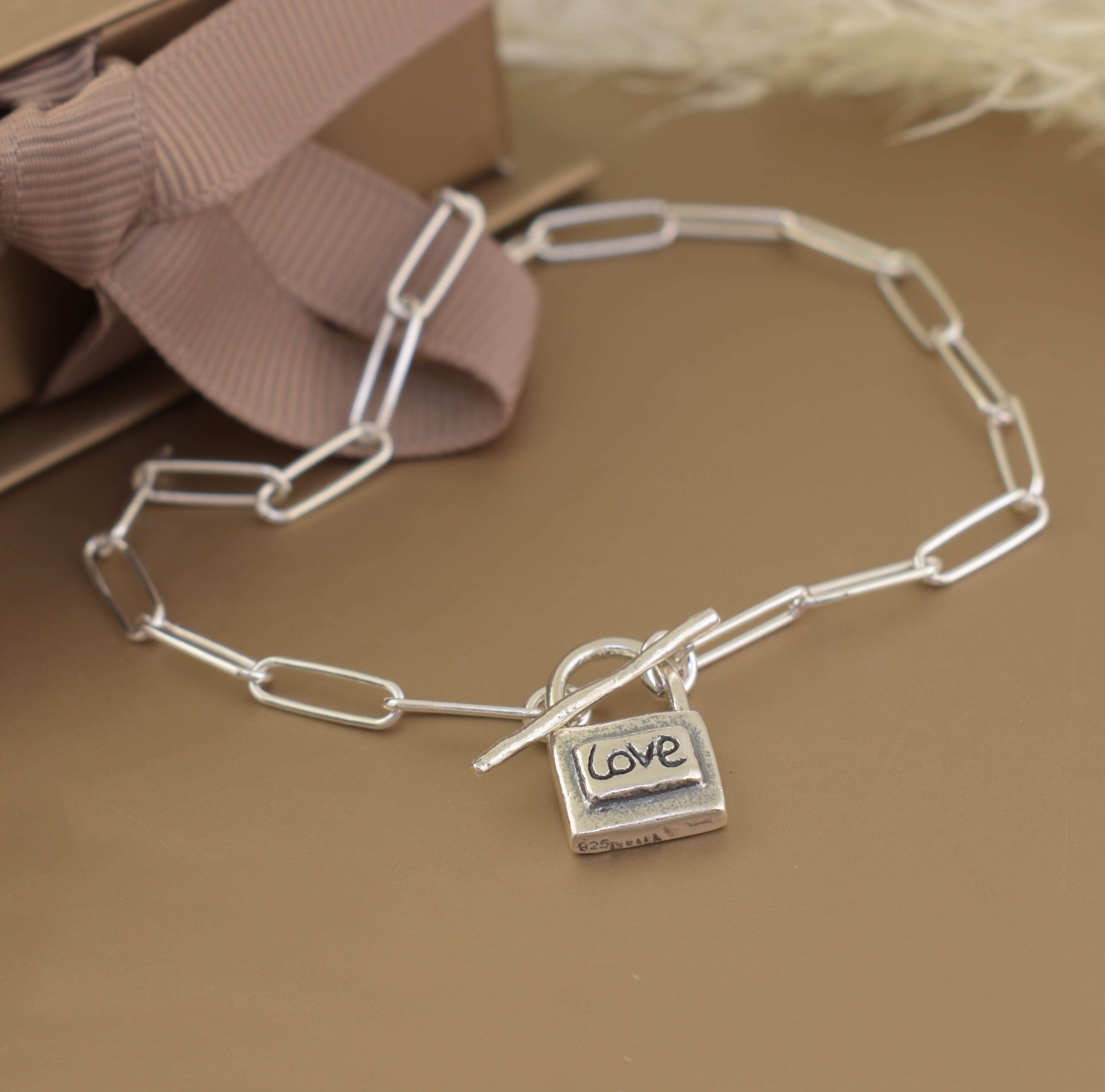 sterling silver paperclip bracelet featuring a lock pendant hand-stamped with Love