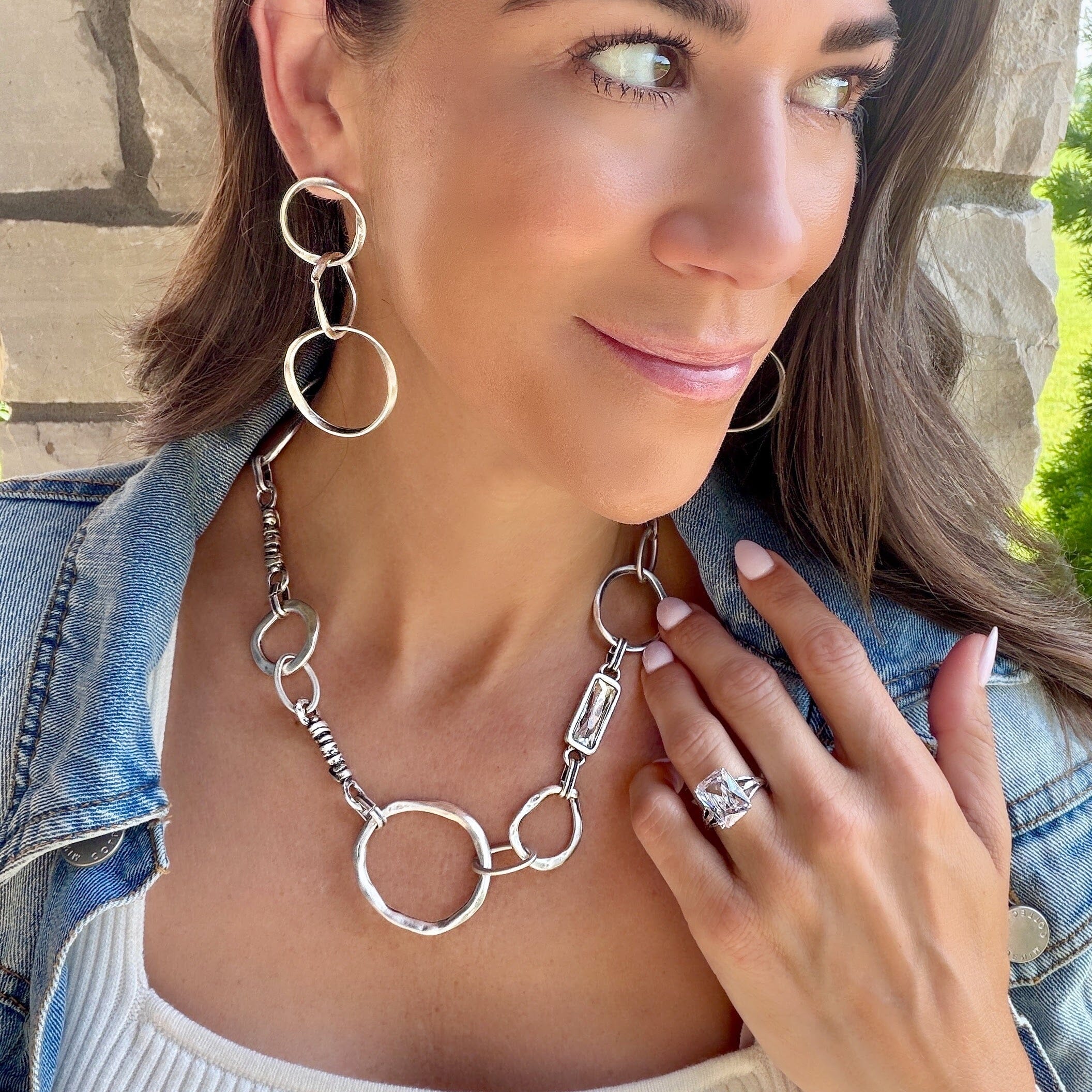silver statement necklace featuring links and a clear stone