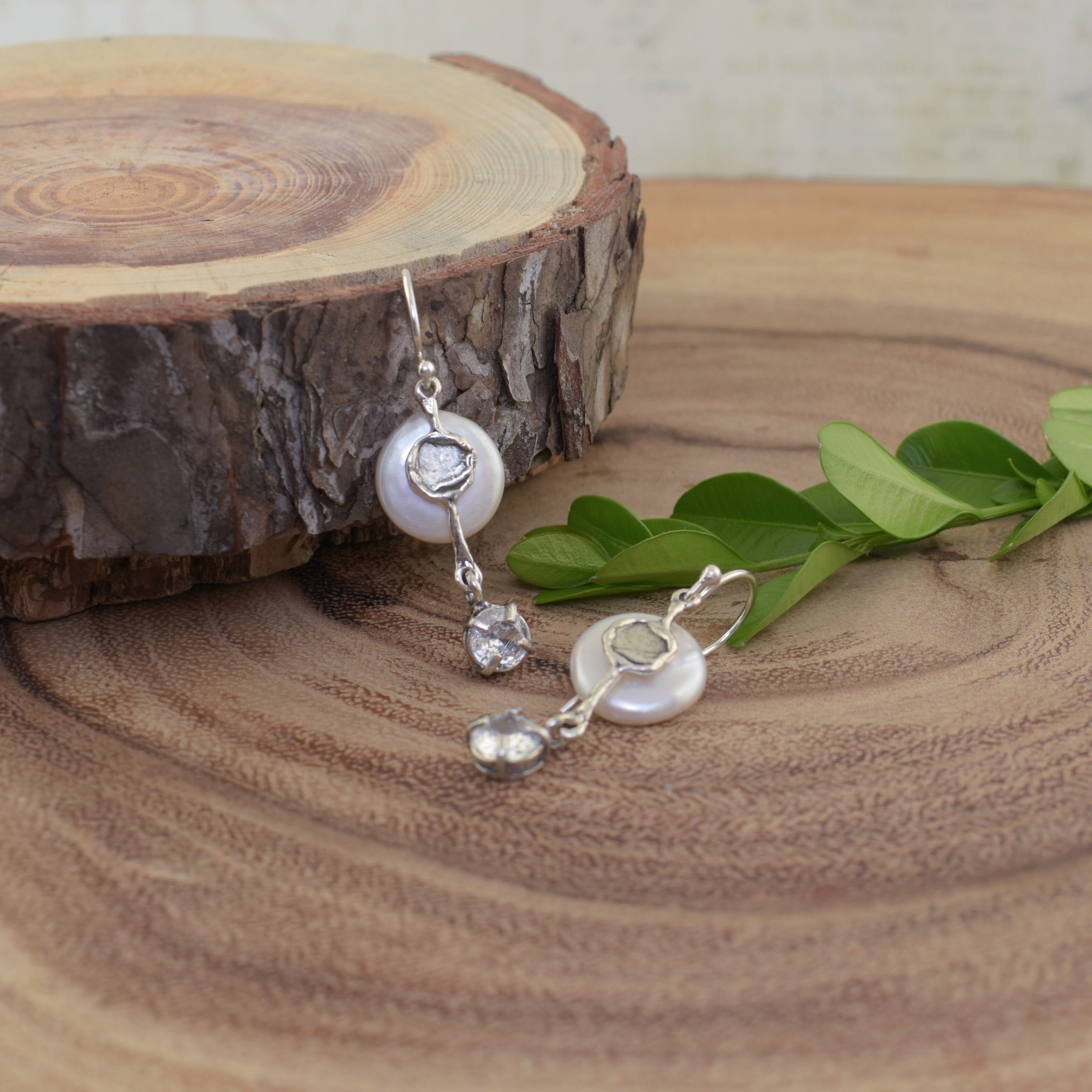 Hook earrings featuring a freshwater coin pearl and a dangle CZ stone