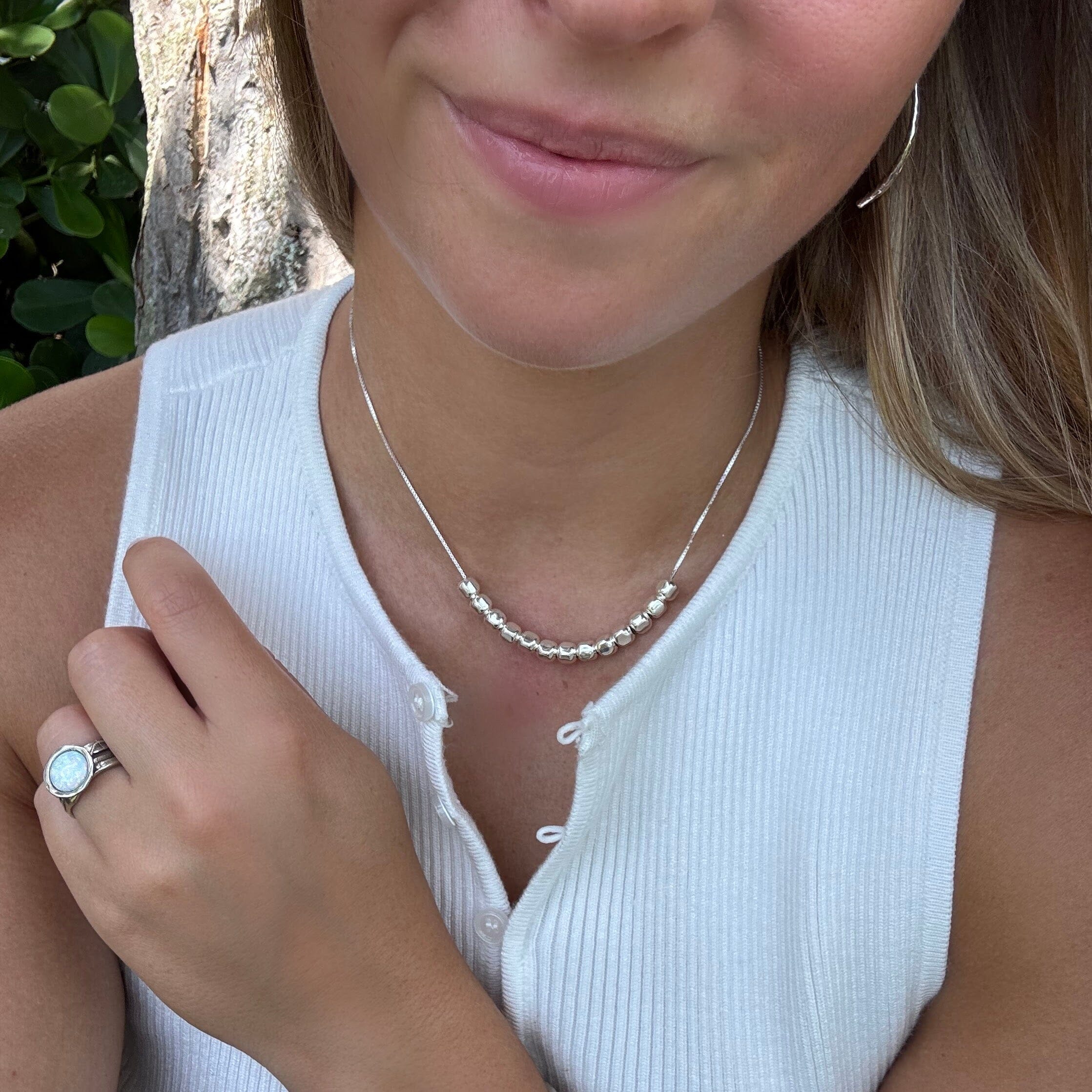 Silver pebble parade necklace paired with white opal ring