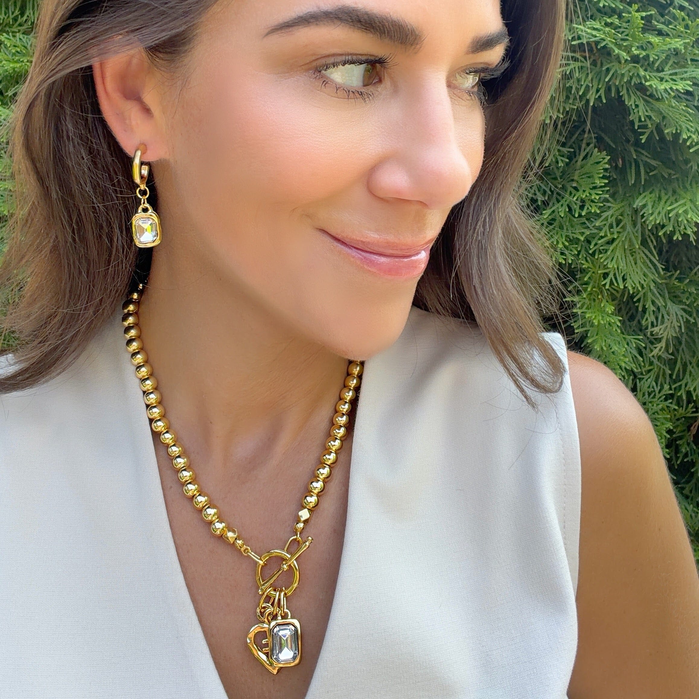 a rectangular cz hanging from a minimalist-style hoop earring