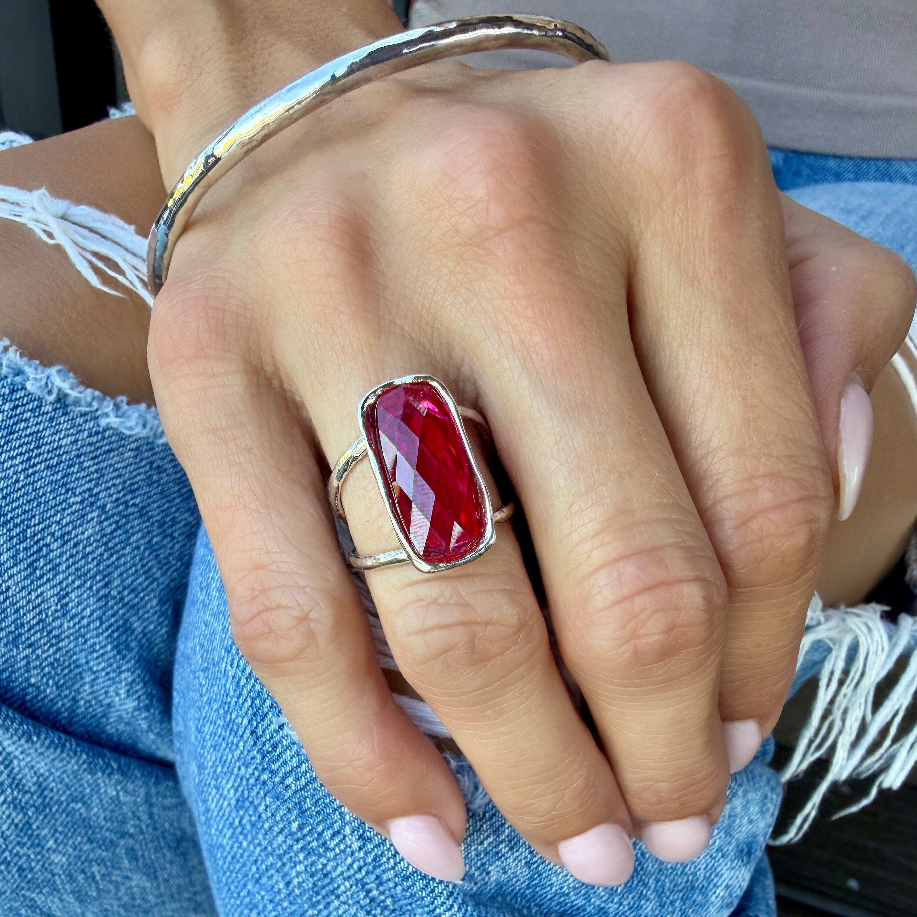 raspberry colored glass sone bezel-set in a sterling silver open style ring