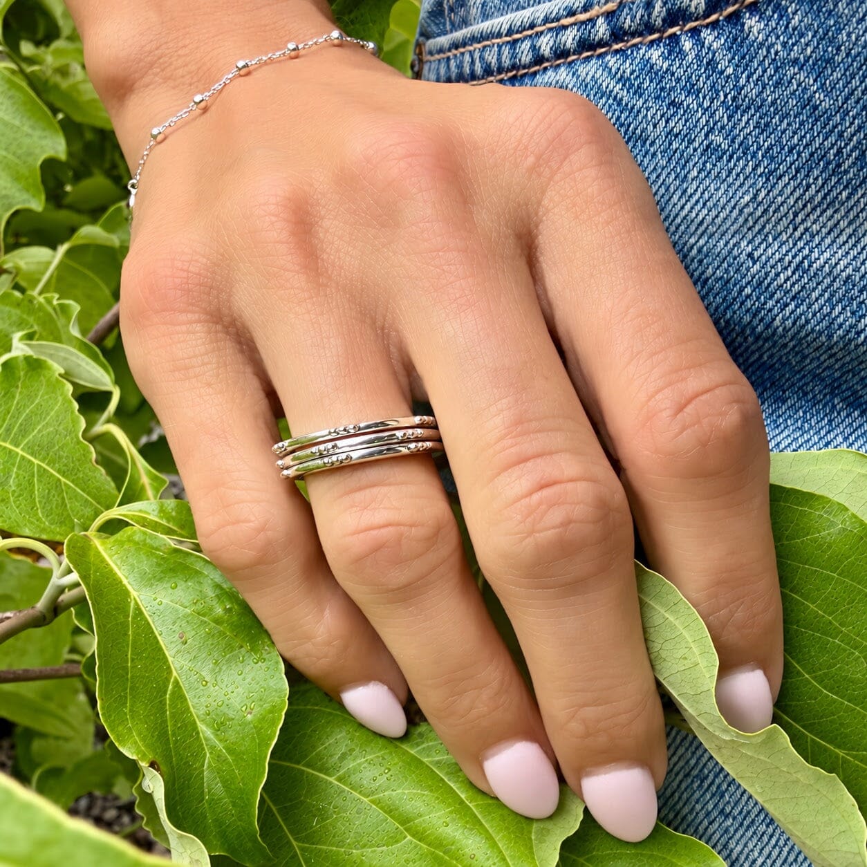 A model wearing a sterling silver thin band ring with little ball details spaced along the edge of the band