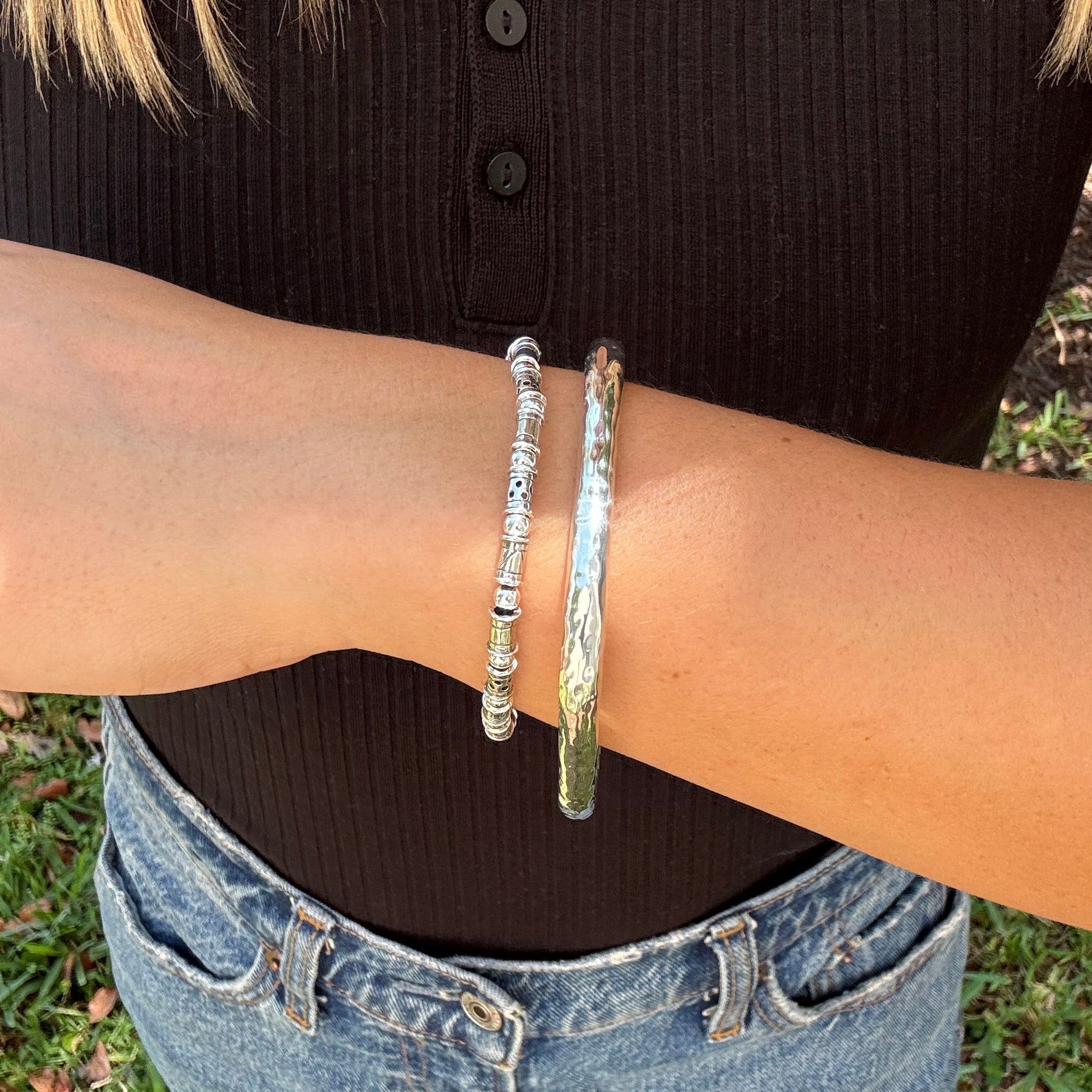 thin tube and round bead bracelet in sterling silver paired with a hammered silver bangle
