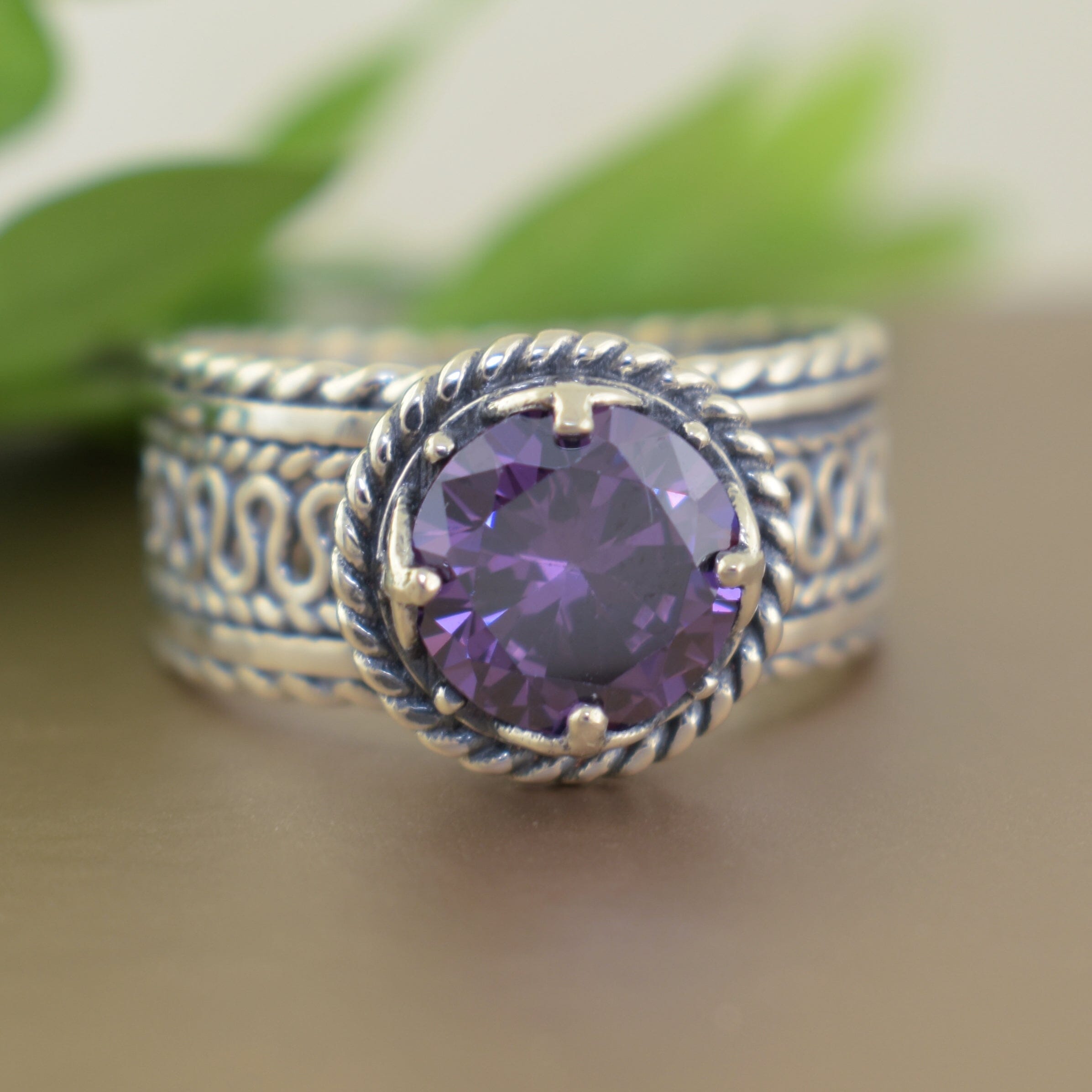 Handcrafted .925 sterling silver ring with twisted bezel and round purple colored cz stone