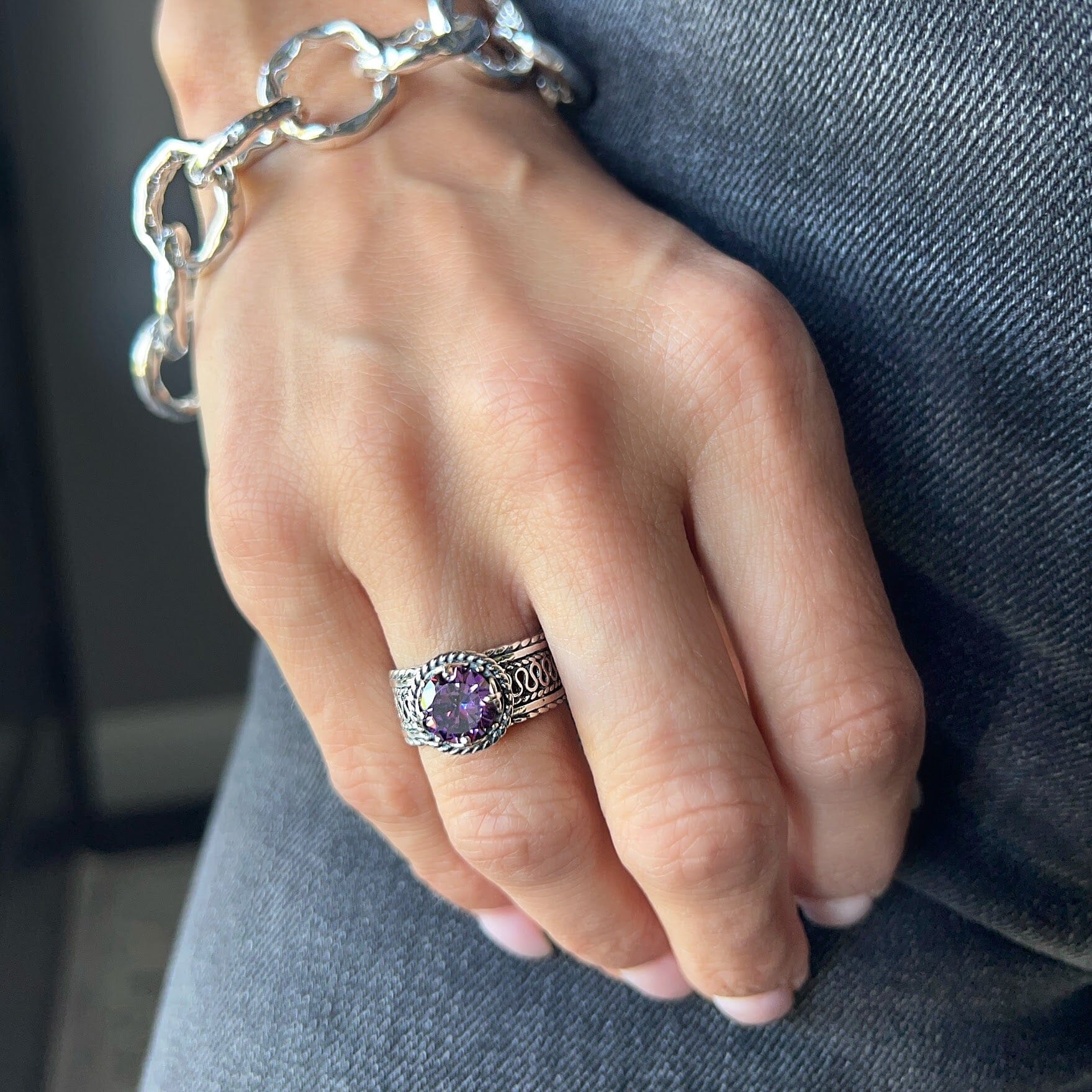 silver designer ring featuring a prong set royal purple cz center