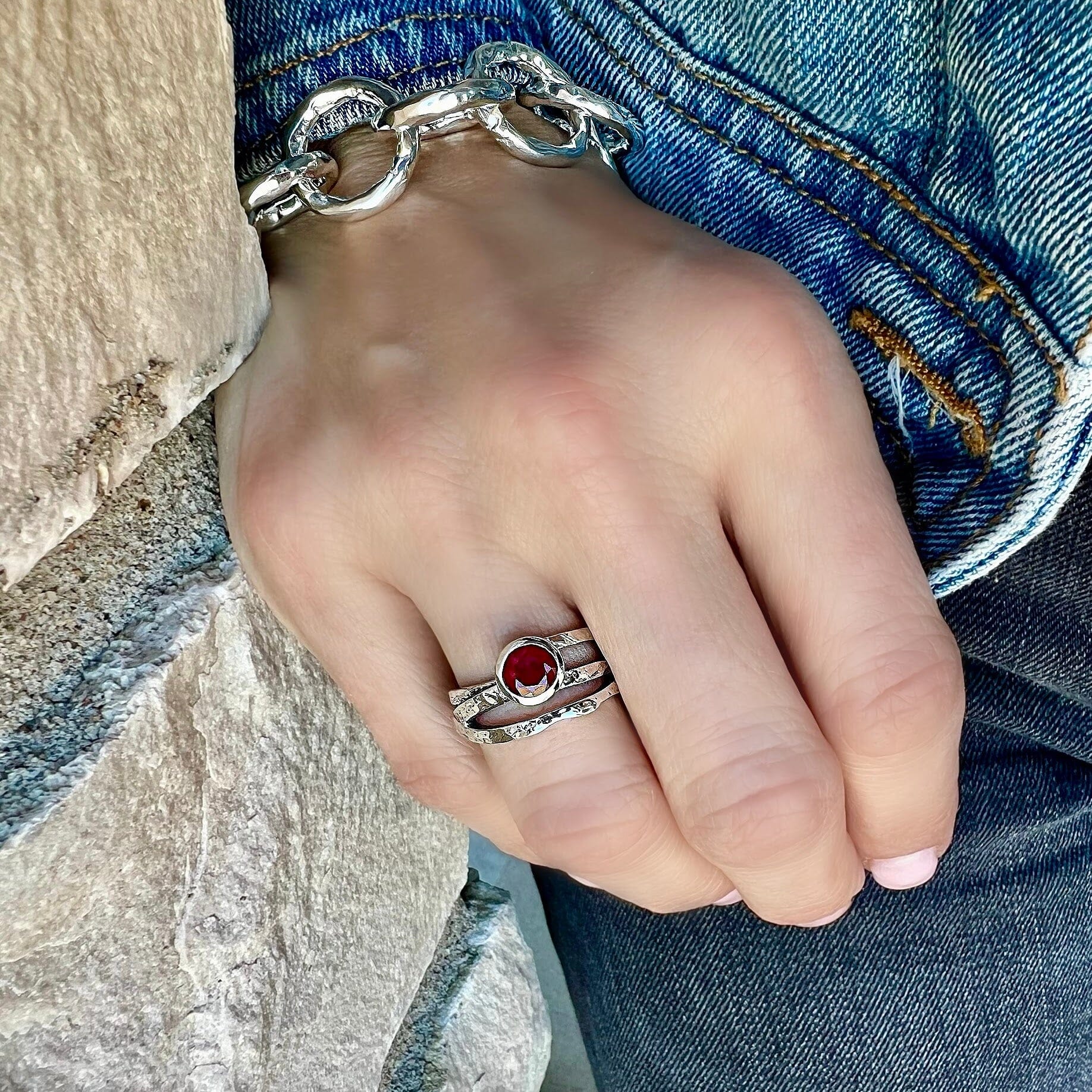 sterling silver ring with crisscross bands featuring a ruby cz stone bezel set