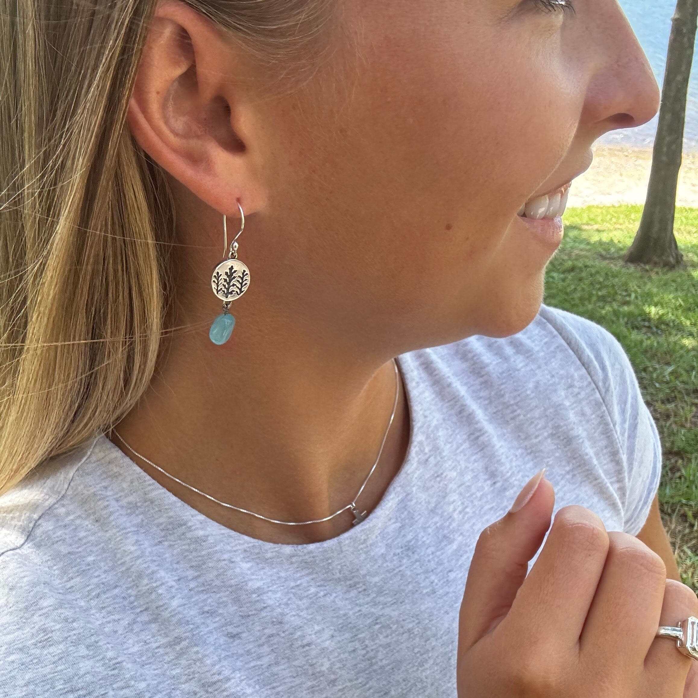 hook earrings with a hanging stamped sterling silver disk and a hanging Aqua Mona Lisa Bead 