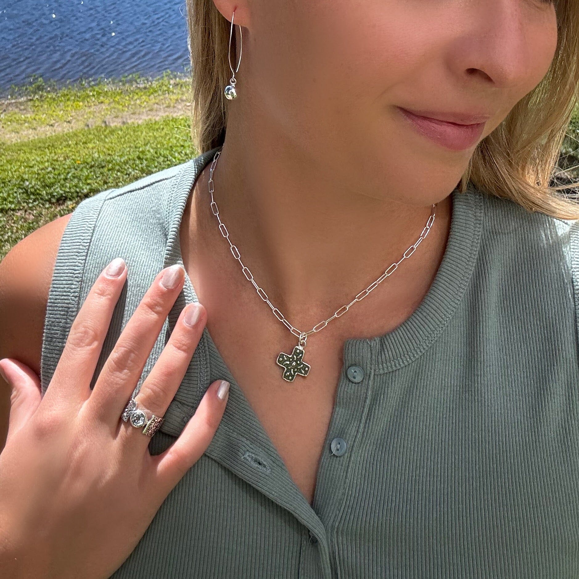 silver necklace with a detailed pendant  paired with dottie earrings 