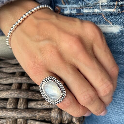 chunky rectangular ring on pinky featuring a shell stone bezel set in a beaded silver frame