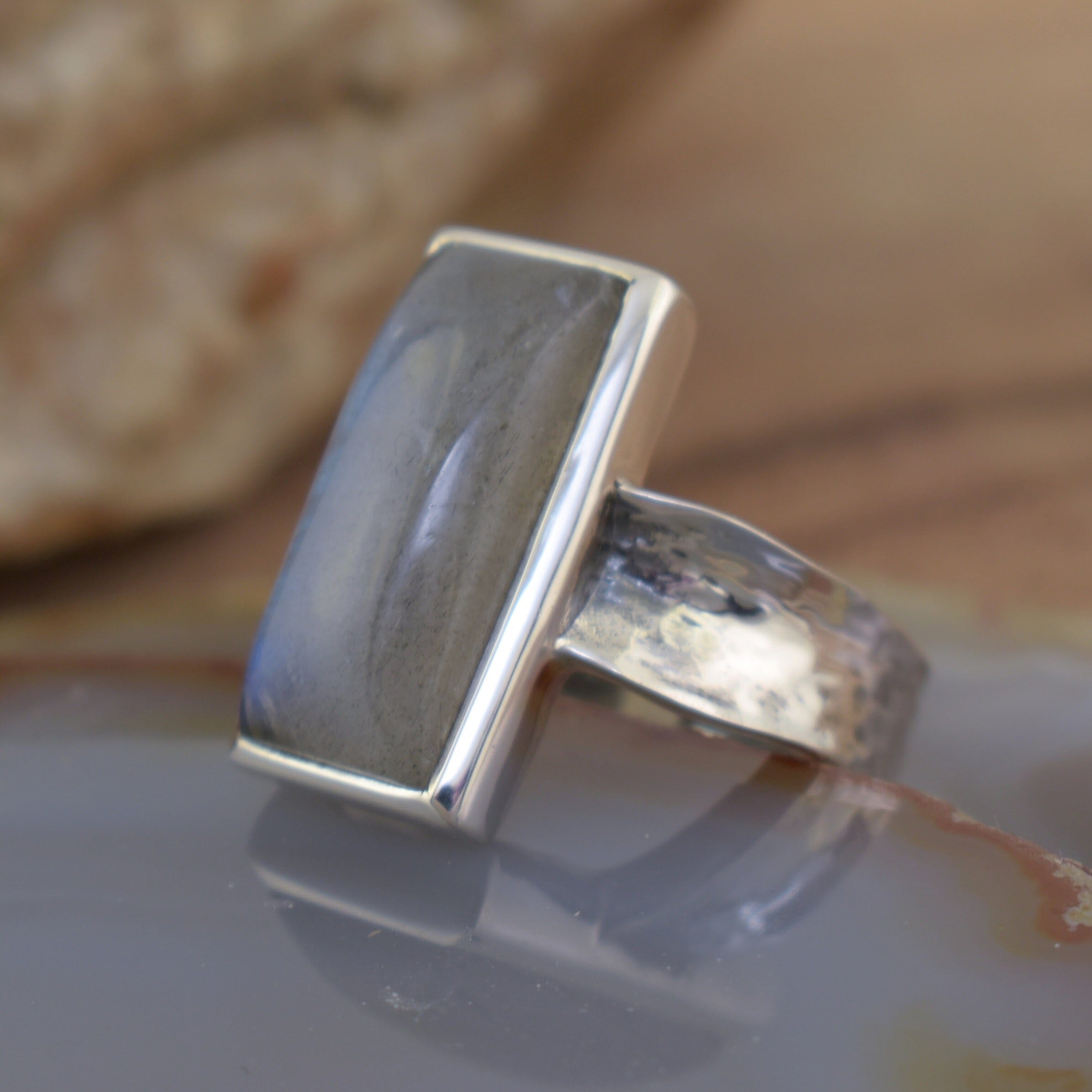 chic, silver ring with a rectangle labradorite center with a thin hammered band