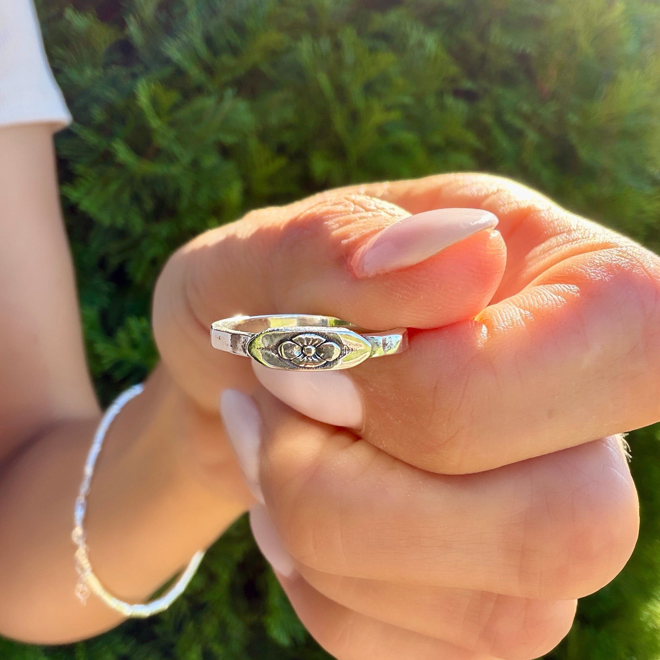 dainty silver hammered band with a small floral center