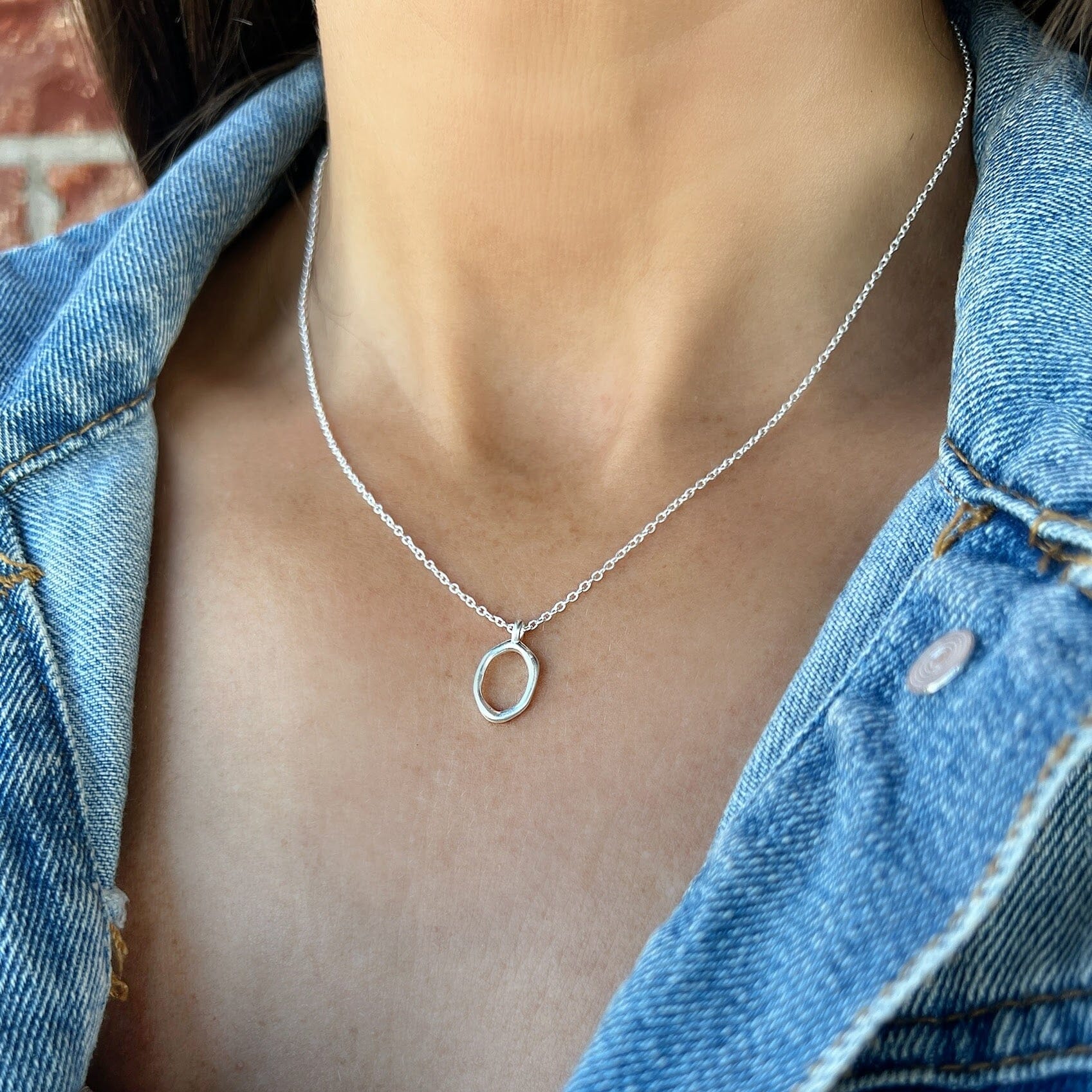 silver open circle pendant on a delicate rolo style chain