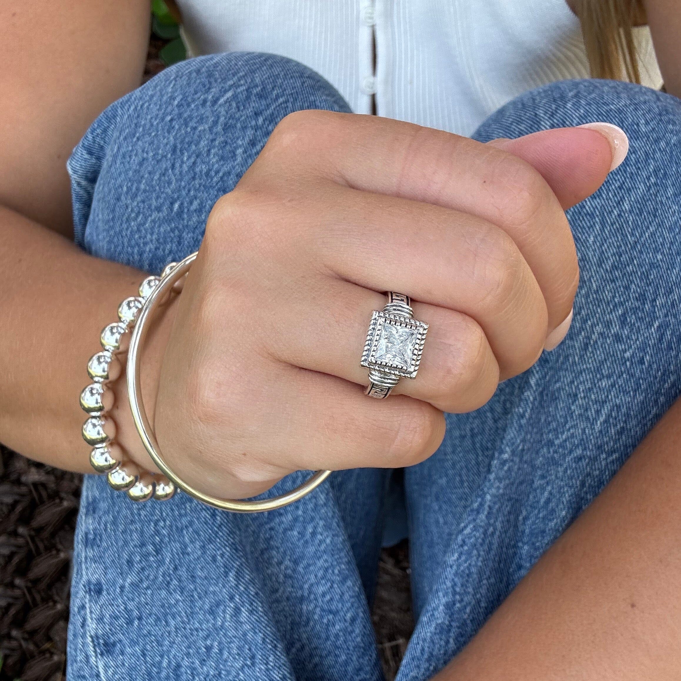 polished and oxidized silver ring with a detailed band and bezel paired with the polished bangle and classic bead bracelet