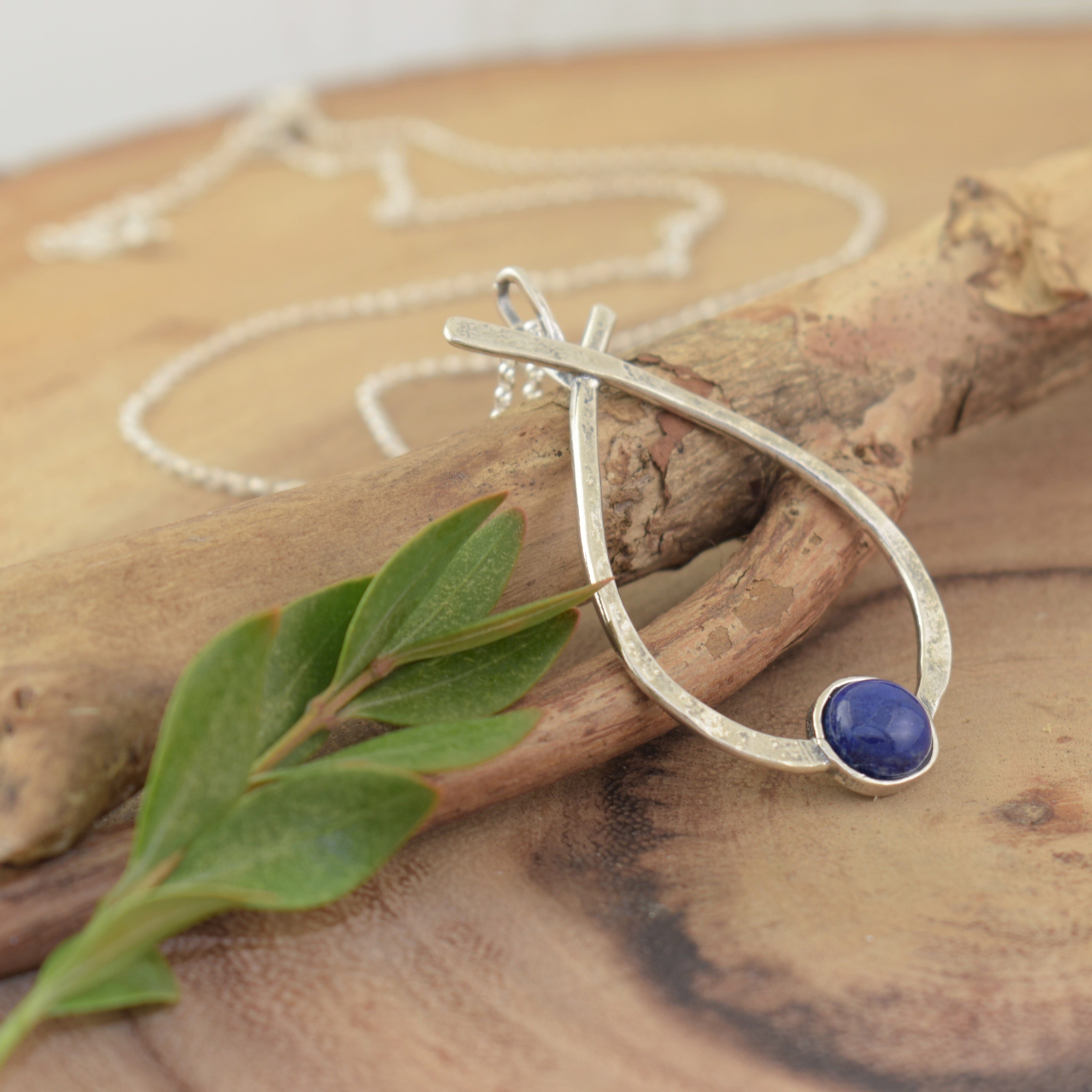 Sterling silver necklace featuring a criss-cross pendant and a Lapis stone