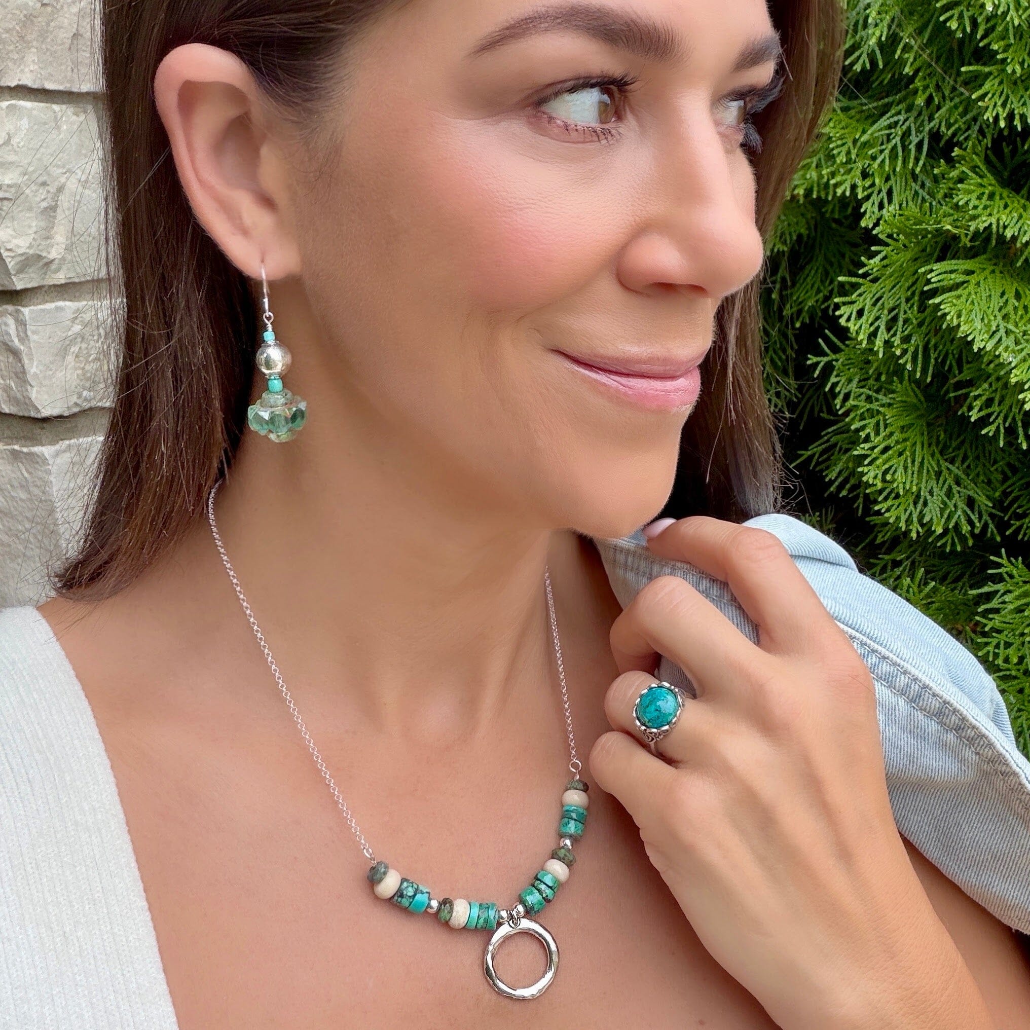 turquoise colored faceted glass beads suspended from a sterling silver hook earring