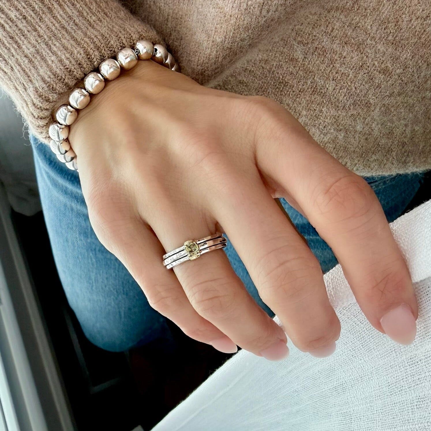 silver spinner ring with a yellow stone