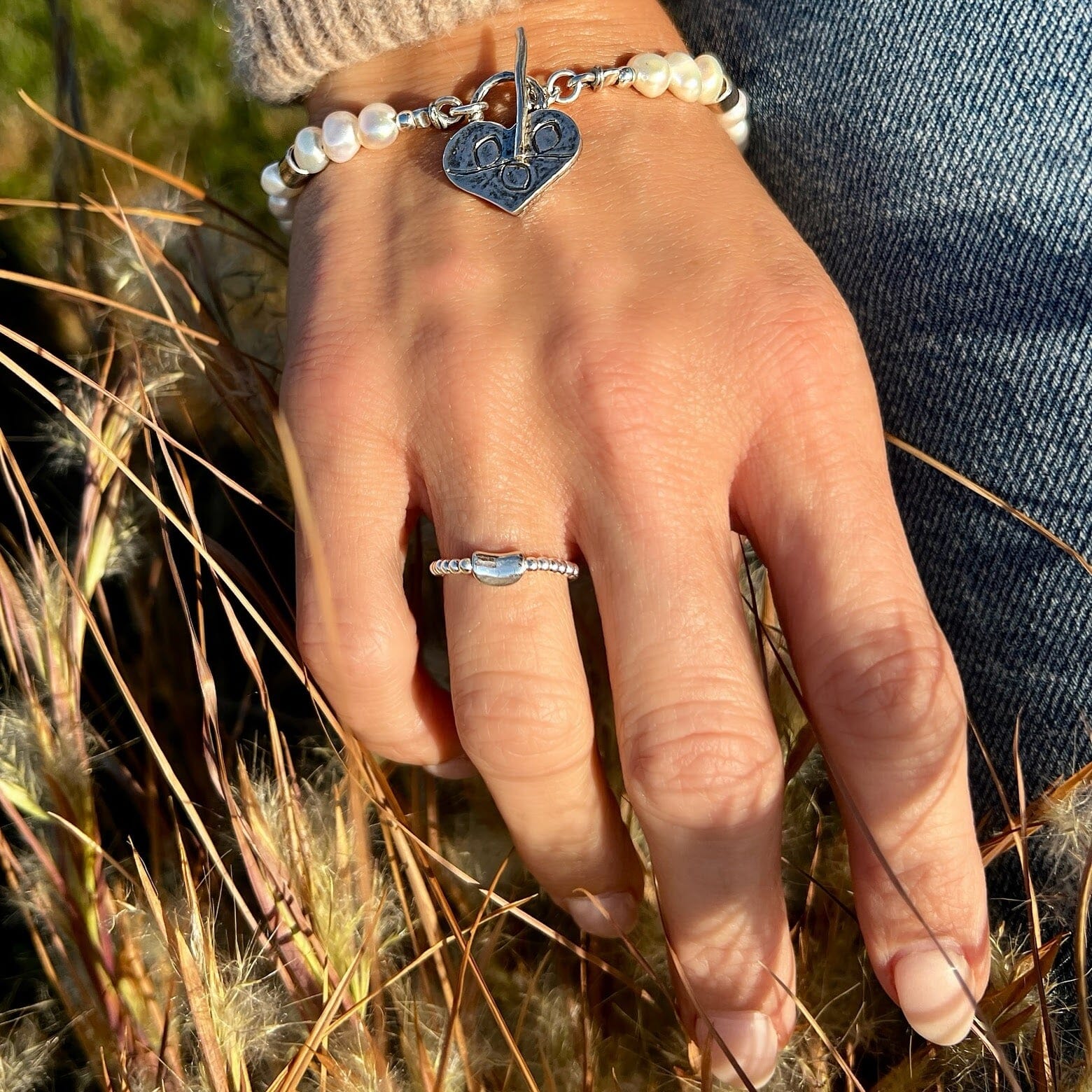 beaded stretch ring featuring a curved silver bar