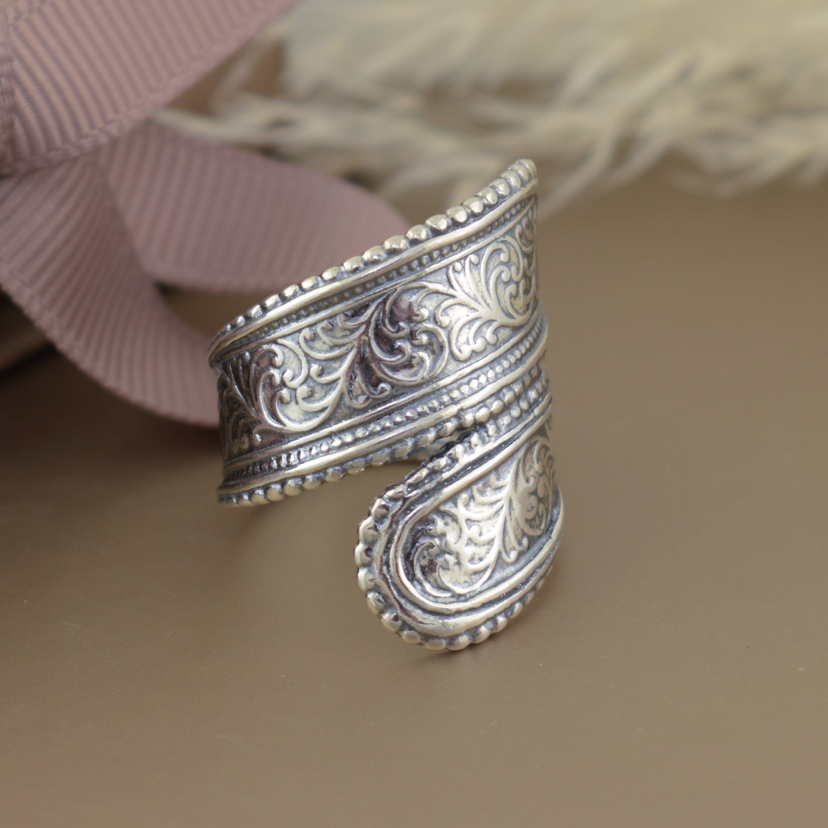 chunky designer silver ring with swirl details and a beaded frame