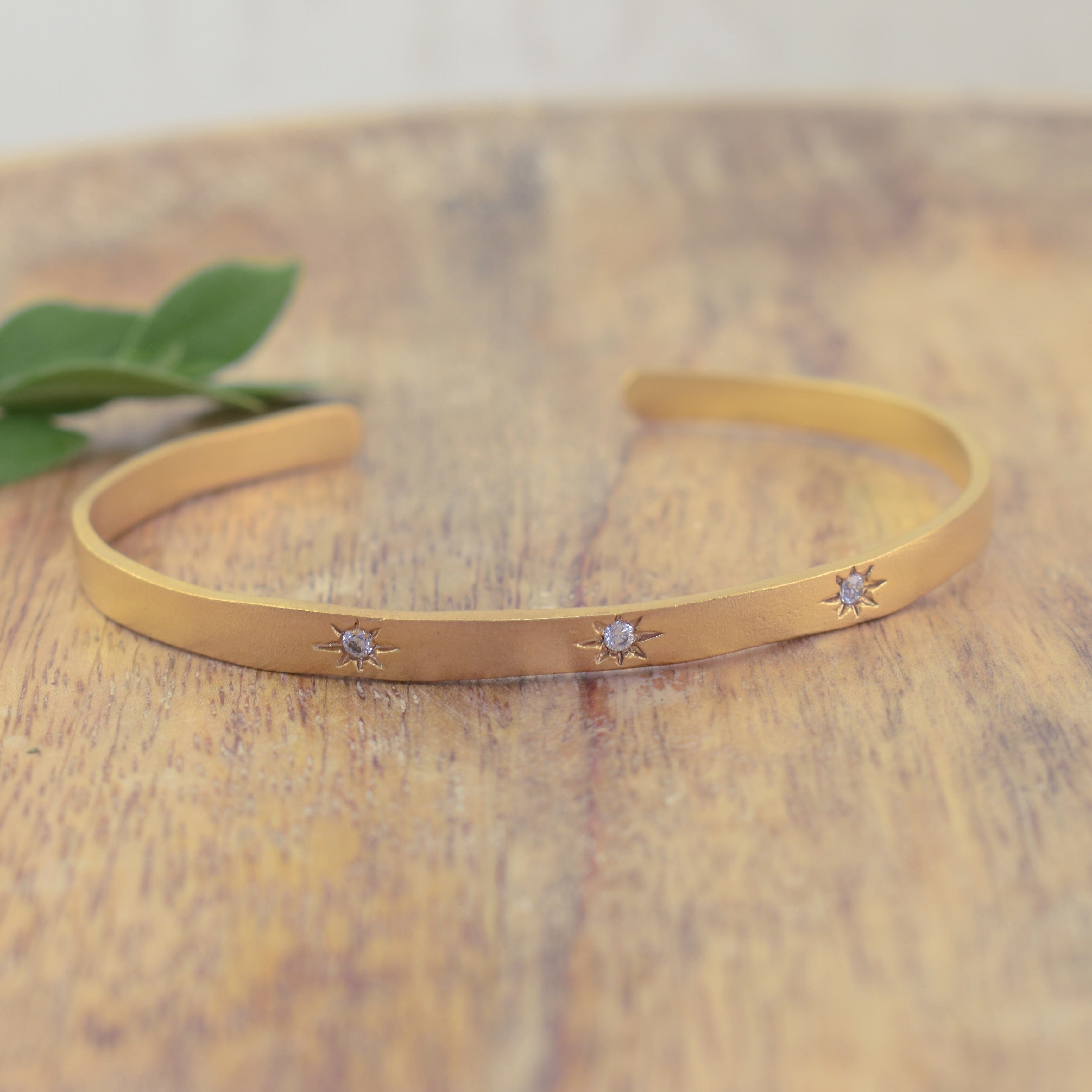 Gold plated cuff with clear stones in engraved stars