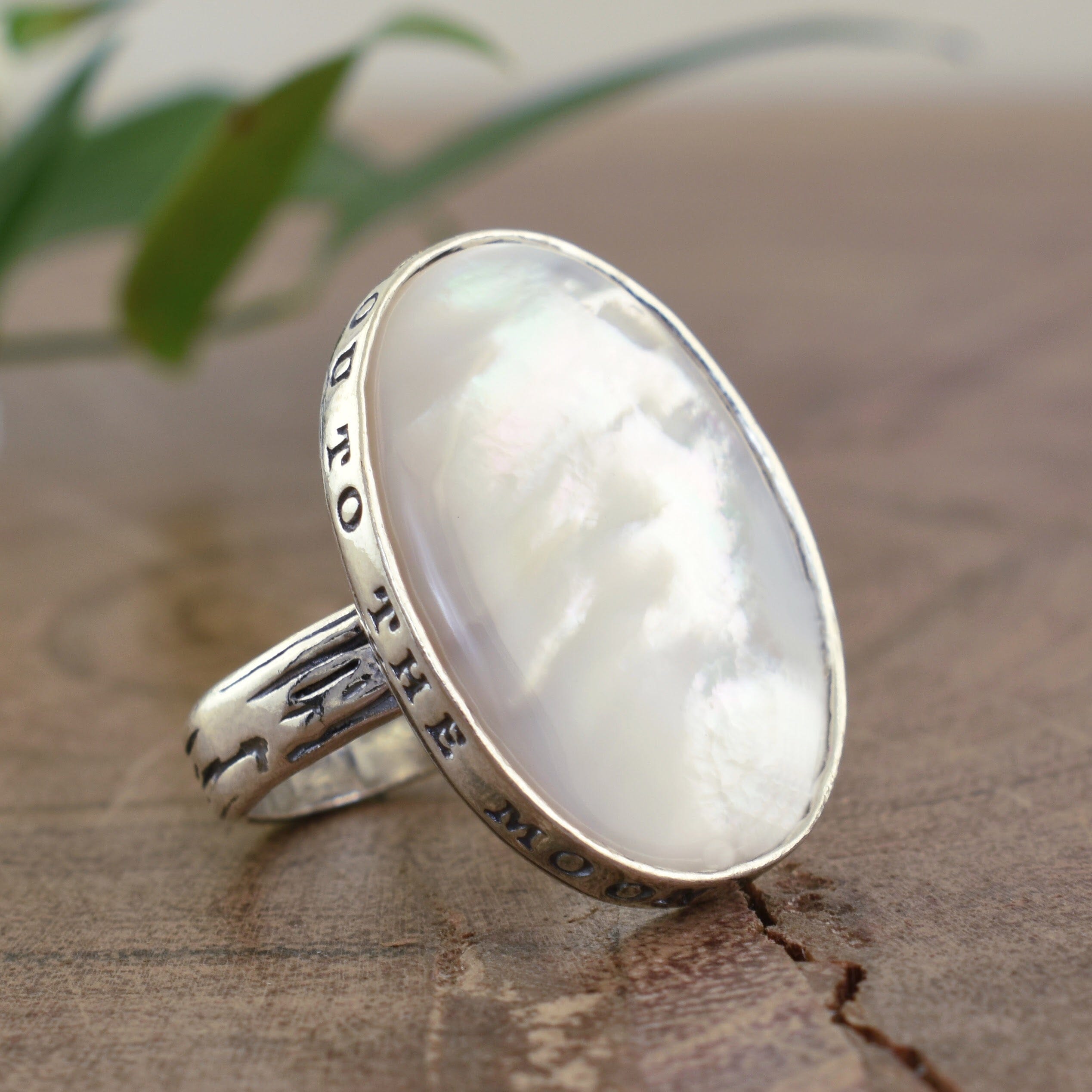 Oval shaped mother of pearl ring hand stamped with I love you to the moon and back phrase