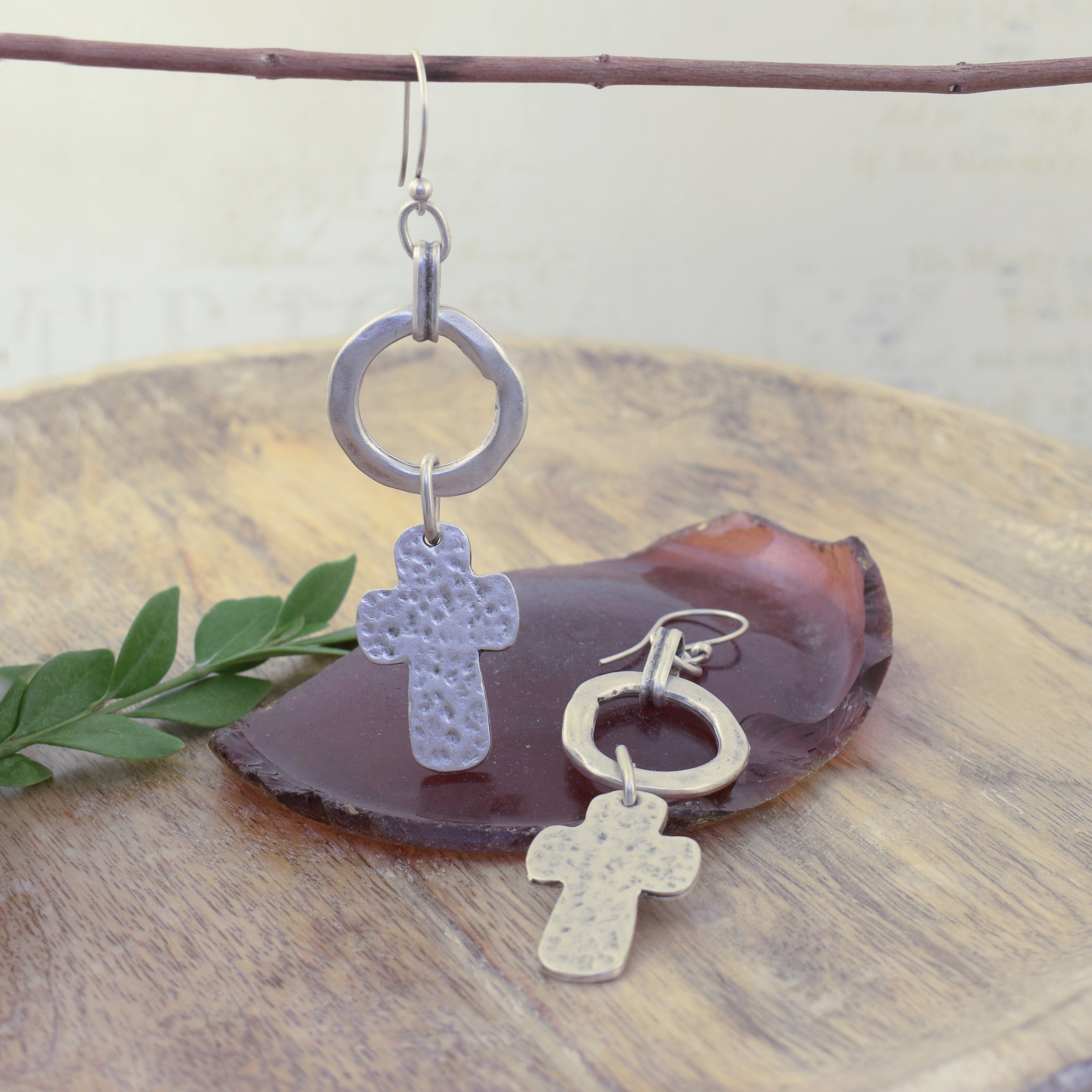 Silver plated earrings with a cross and open ring hung off a french hook