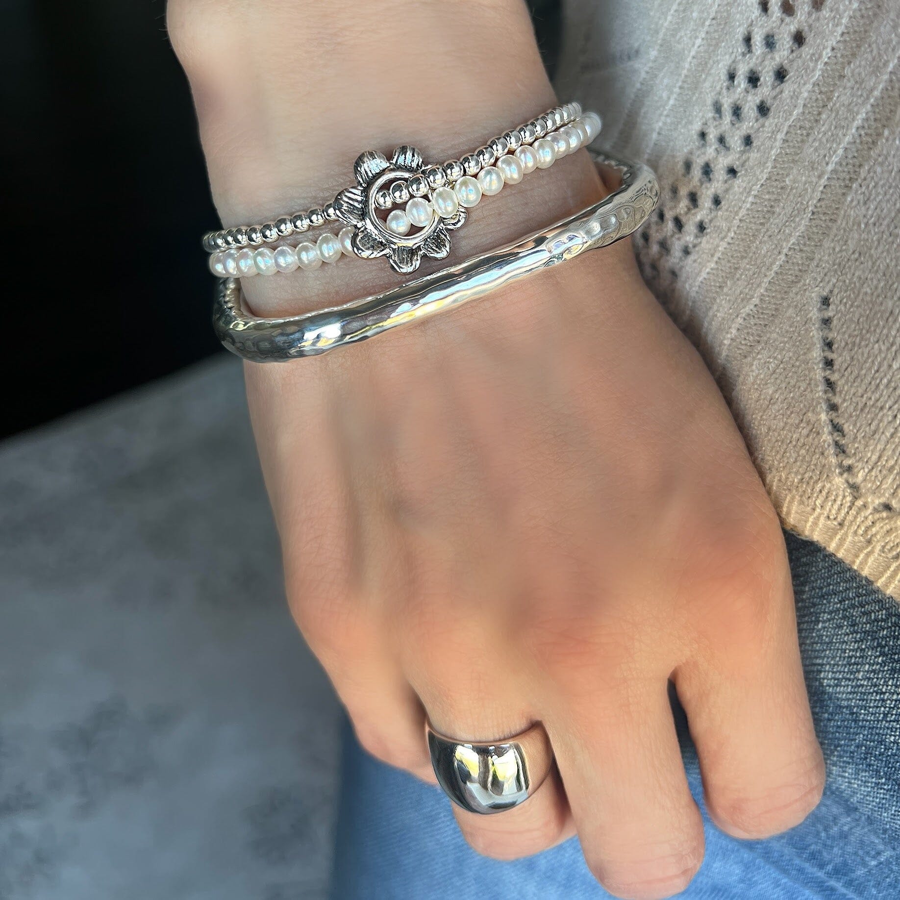 wrapped silver and pearl bracelet held by a silver flower paired with classic dome