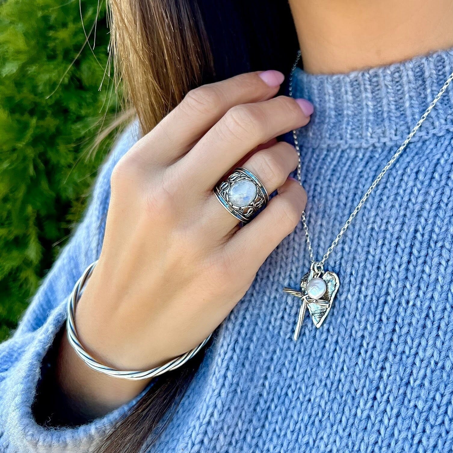 wide silver designer ring featuring oval moonstone center