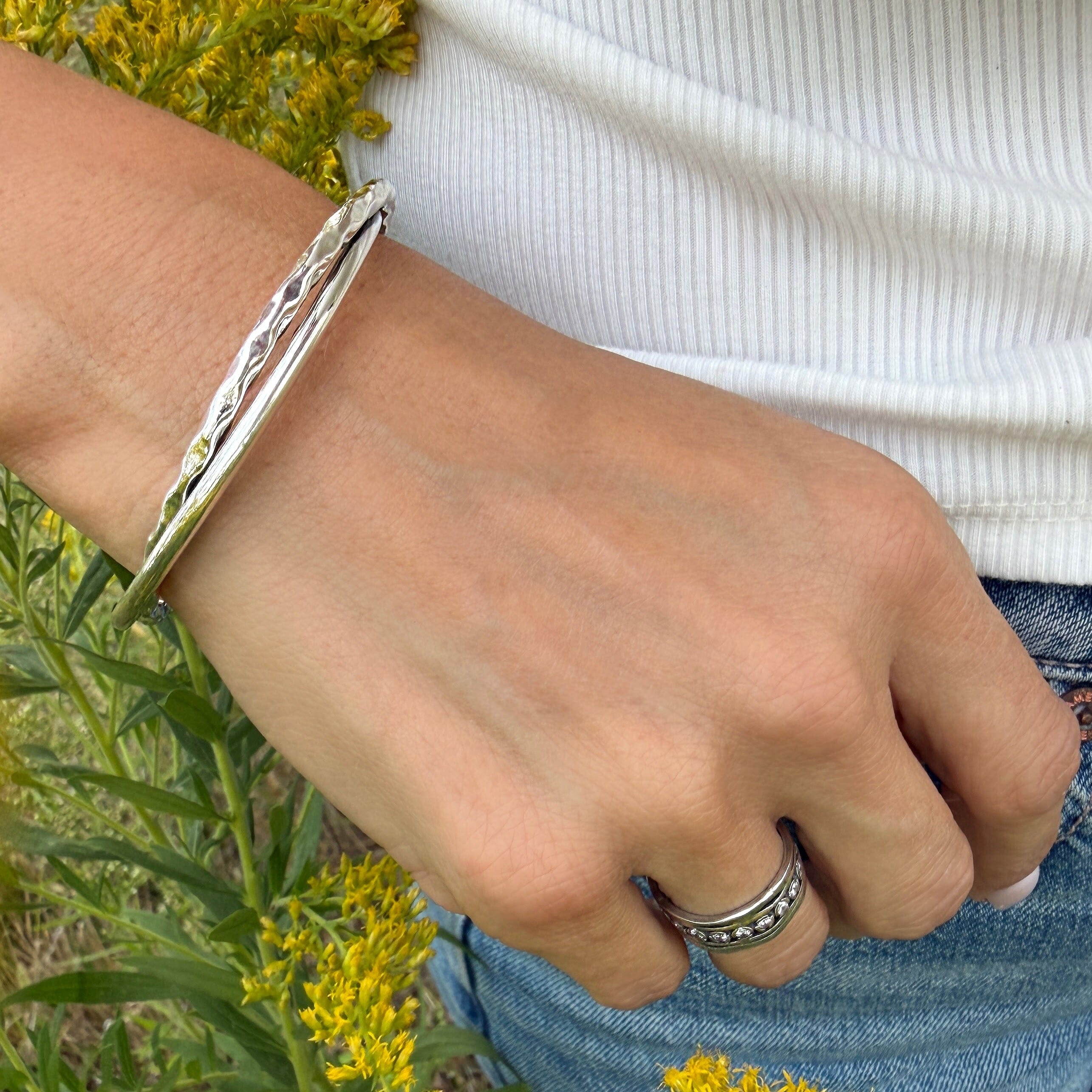 sterling silver cuff bracelet featuring a sleek polished band and a textured band