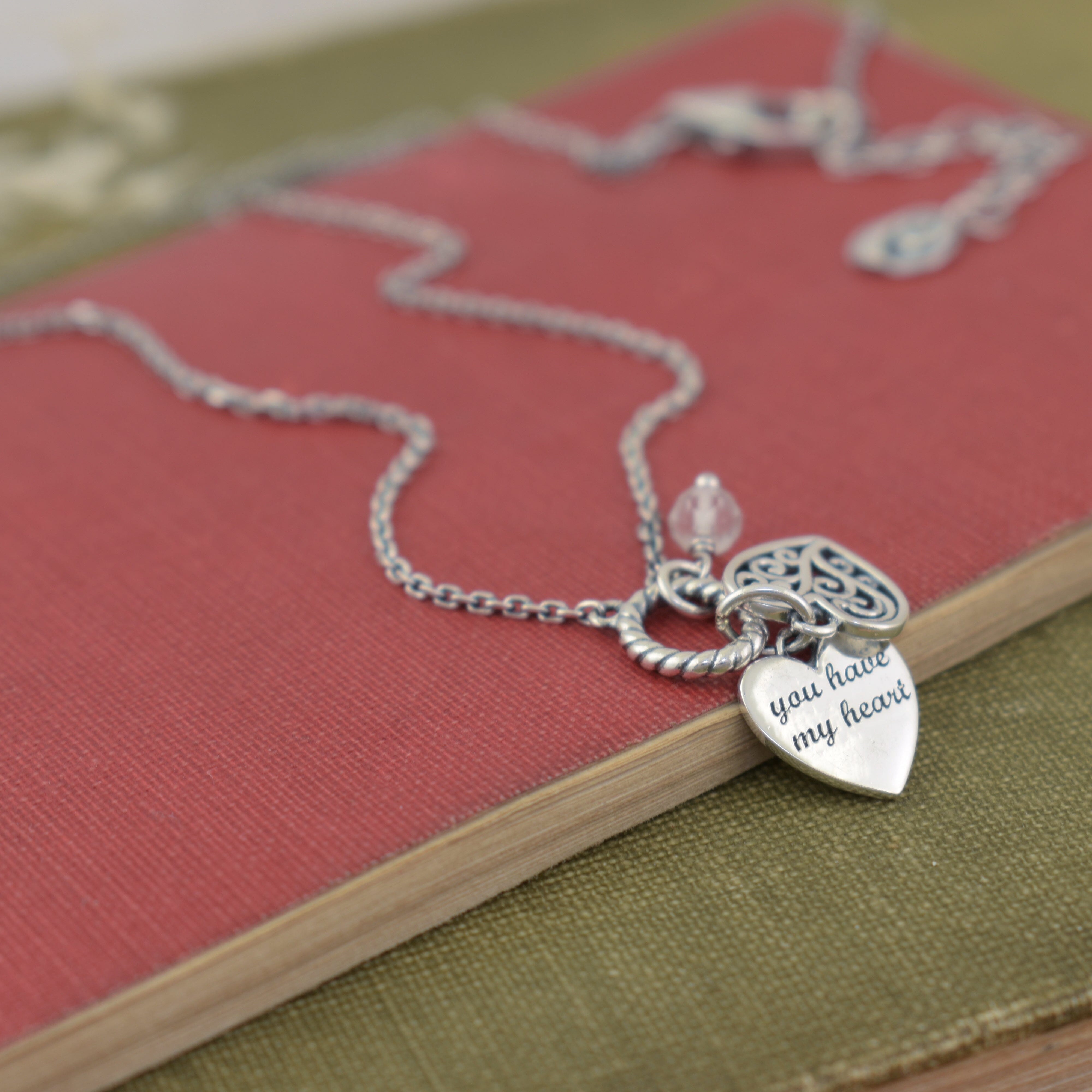 extendable silver necklace featuring a decorative heart pendant and a heart pendant hand stamped with "you have my heart"