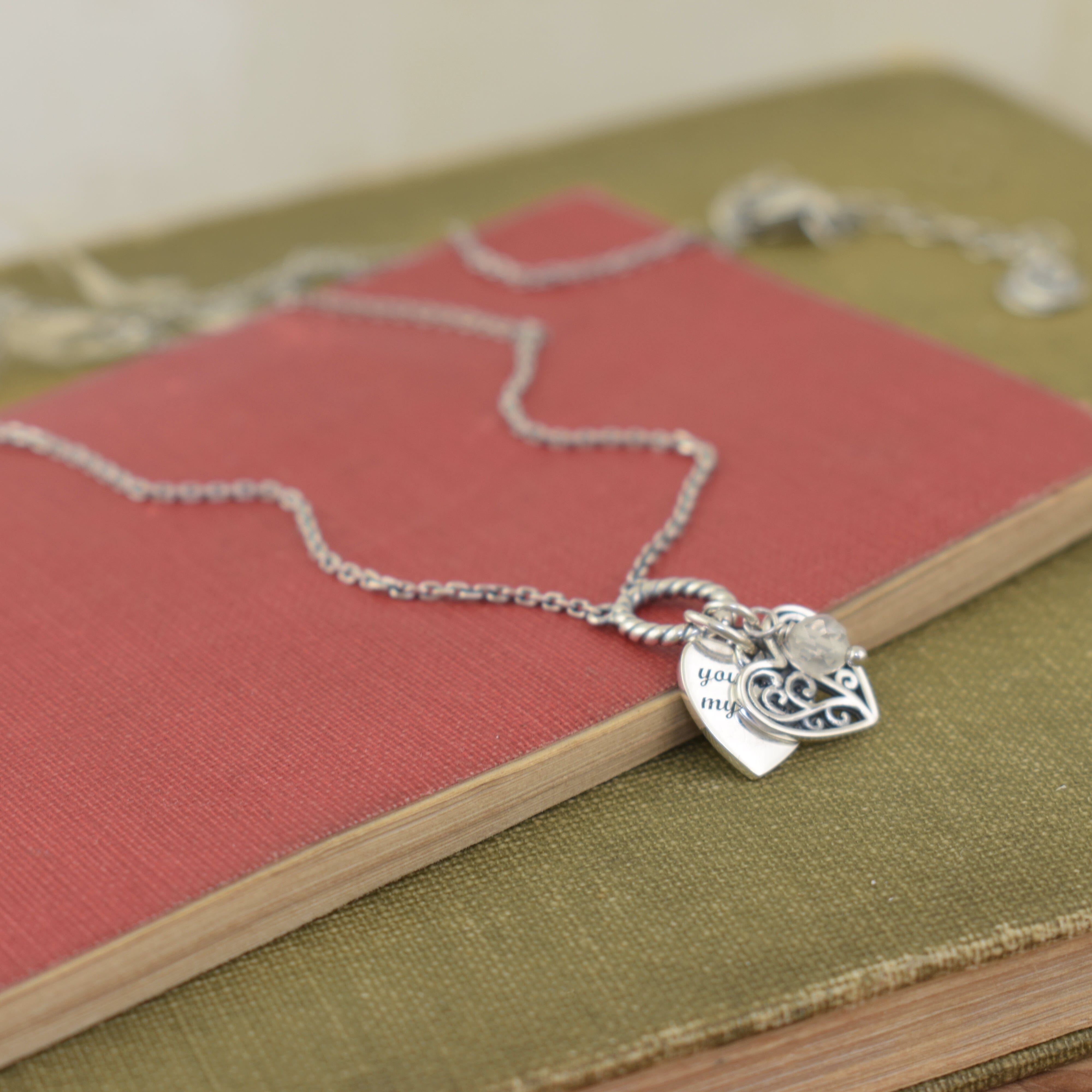 oxidized sterling silver necklace with heart shaped pendants and a clear crystal dangle