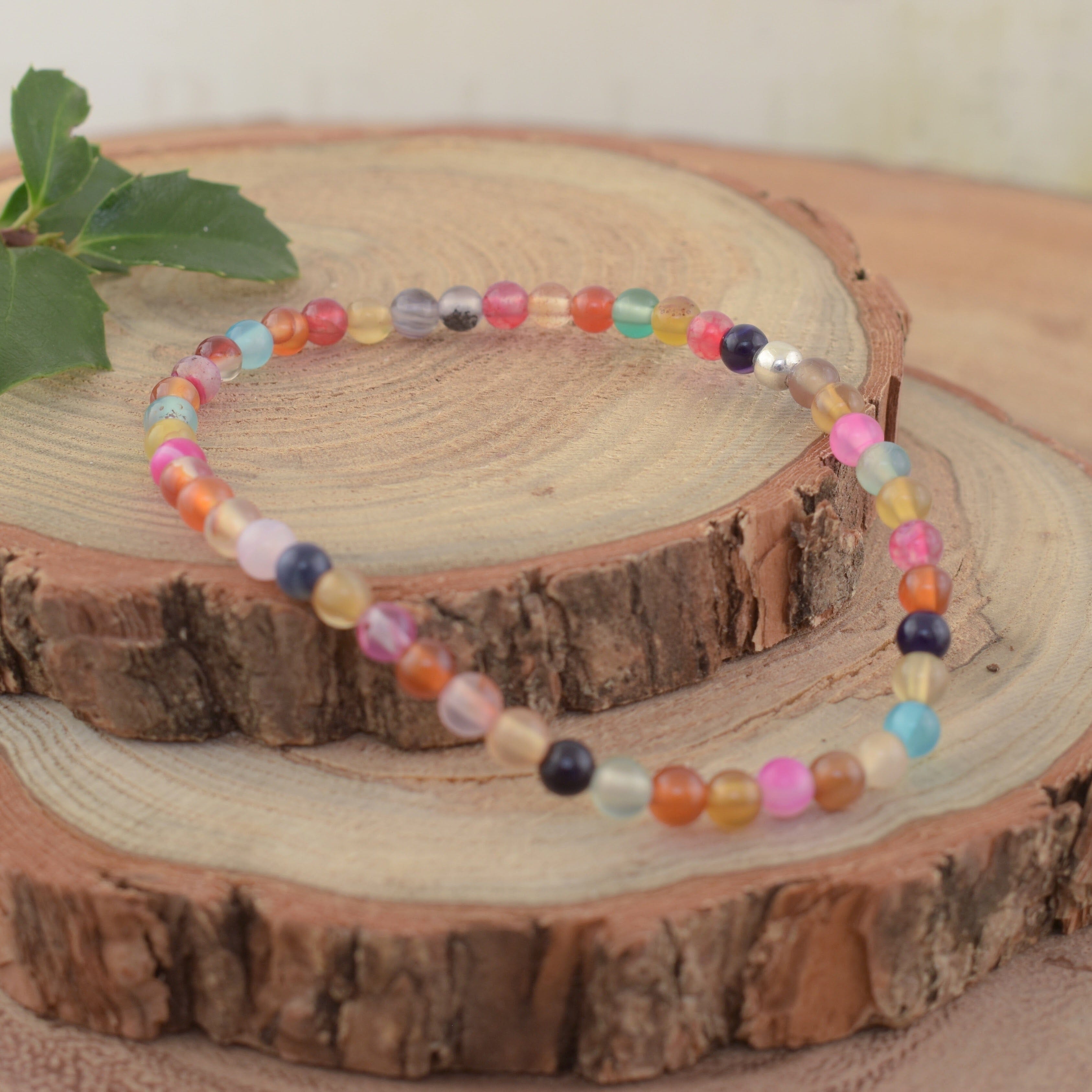A multi-colored bead stretch bracelet with a small sterling silver separator bead
