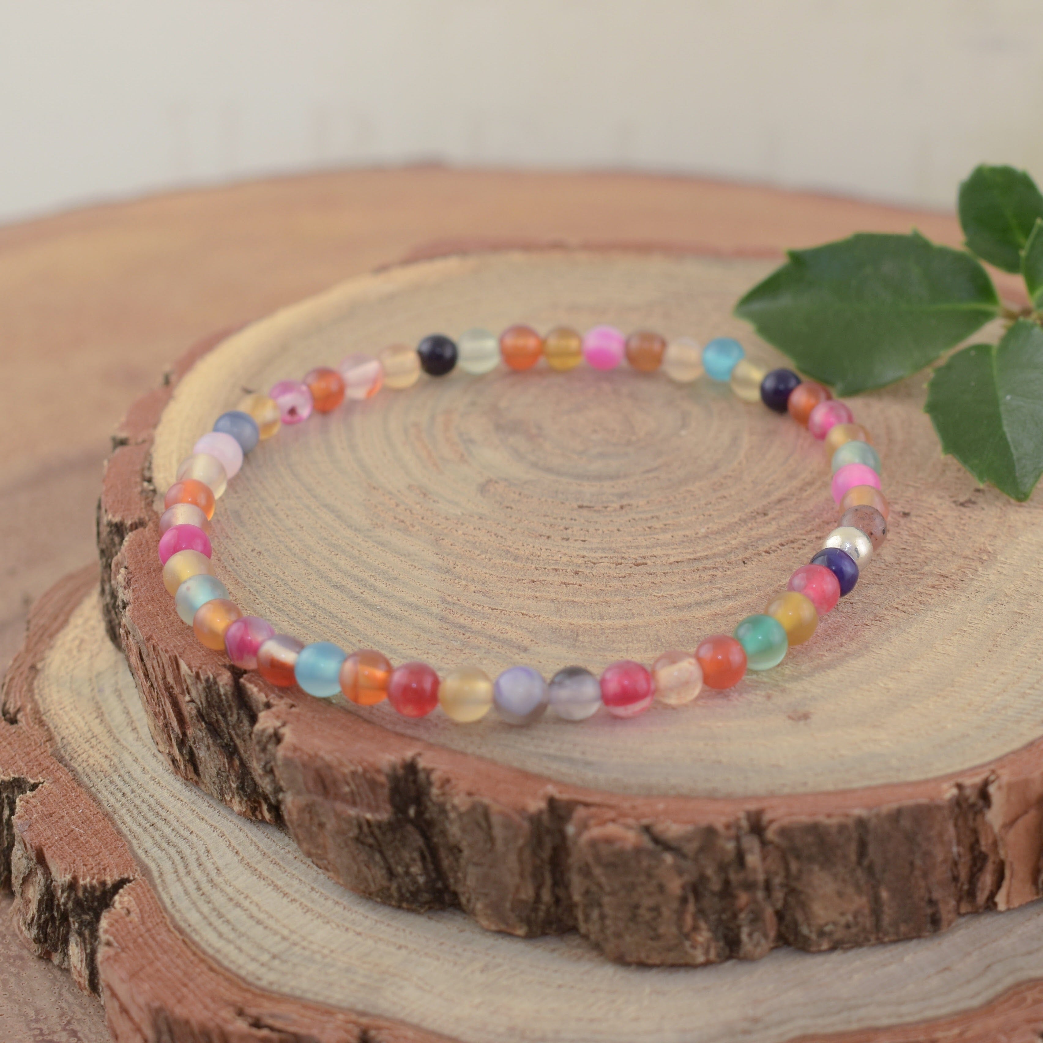 A multi-colored bead stretch bracelet with a small sterling silver separator bead
