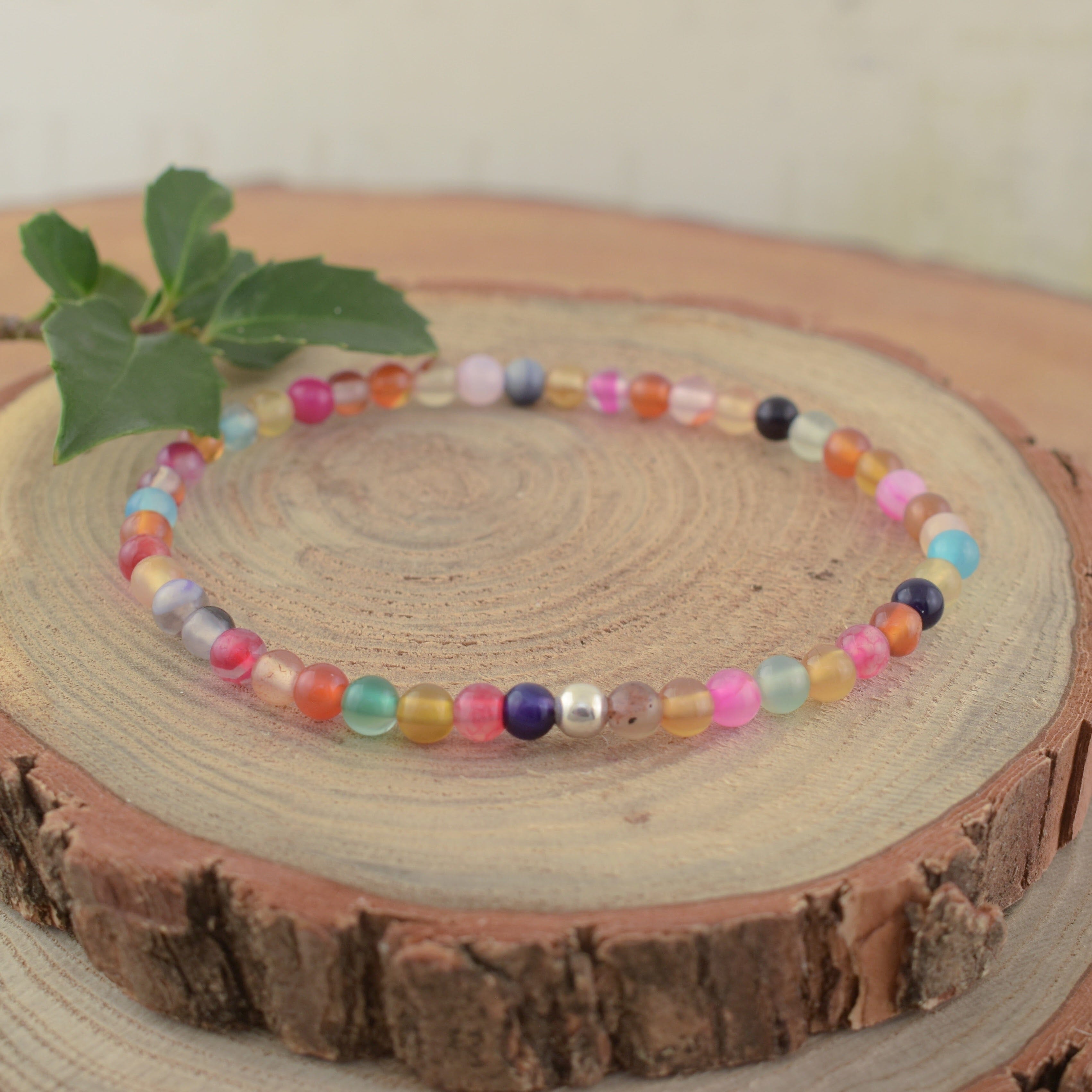 A multi-colored bead stretch bracelet with a small sterling silver separator bead