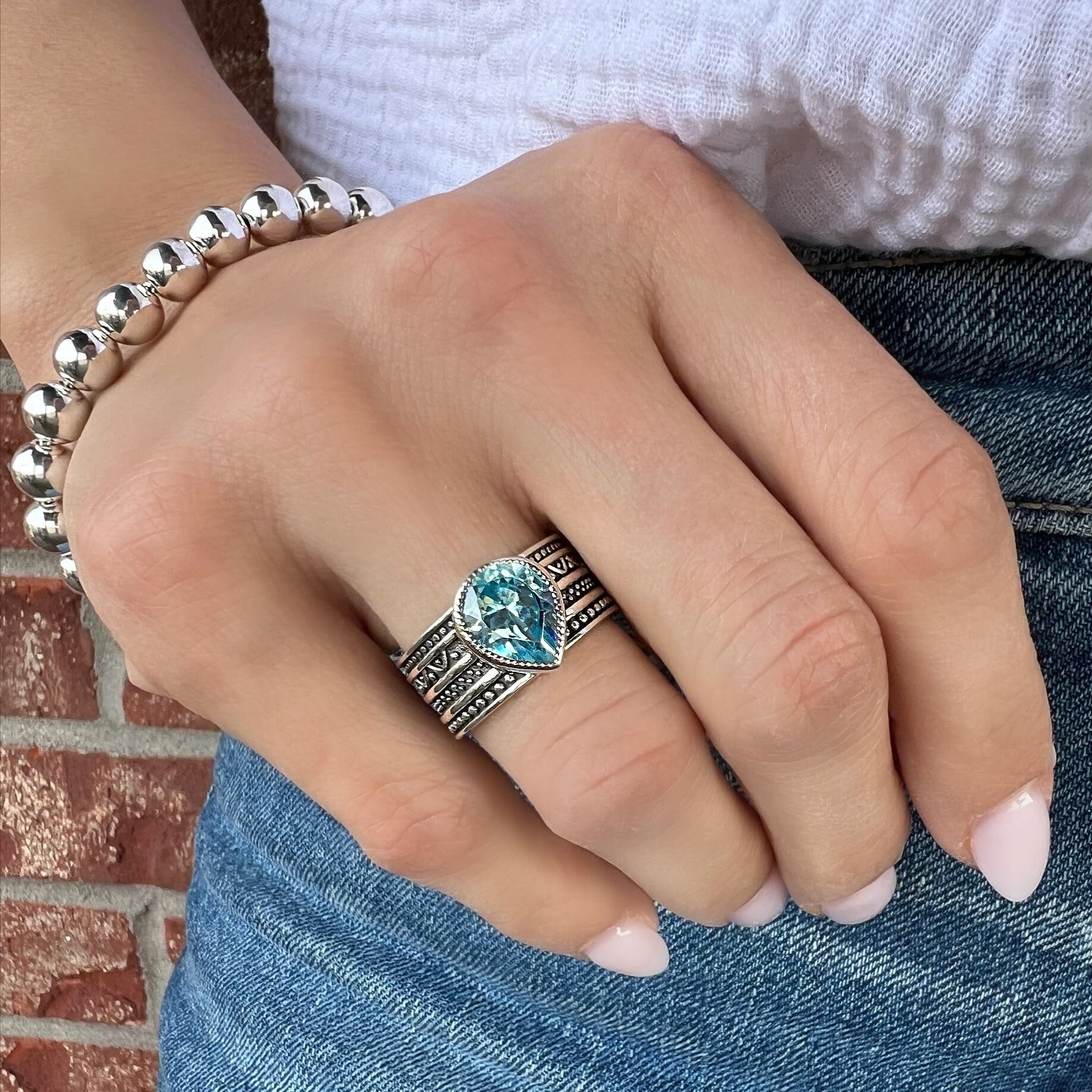 chunky silver ring featuring blue pear-shaped cz