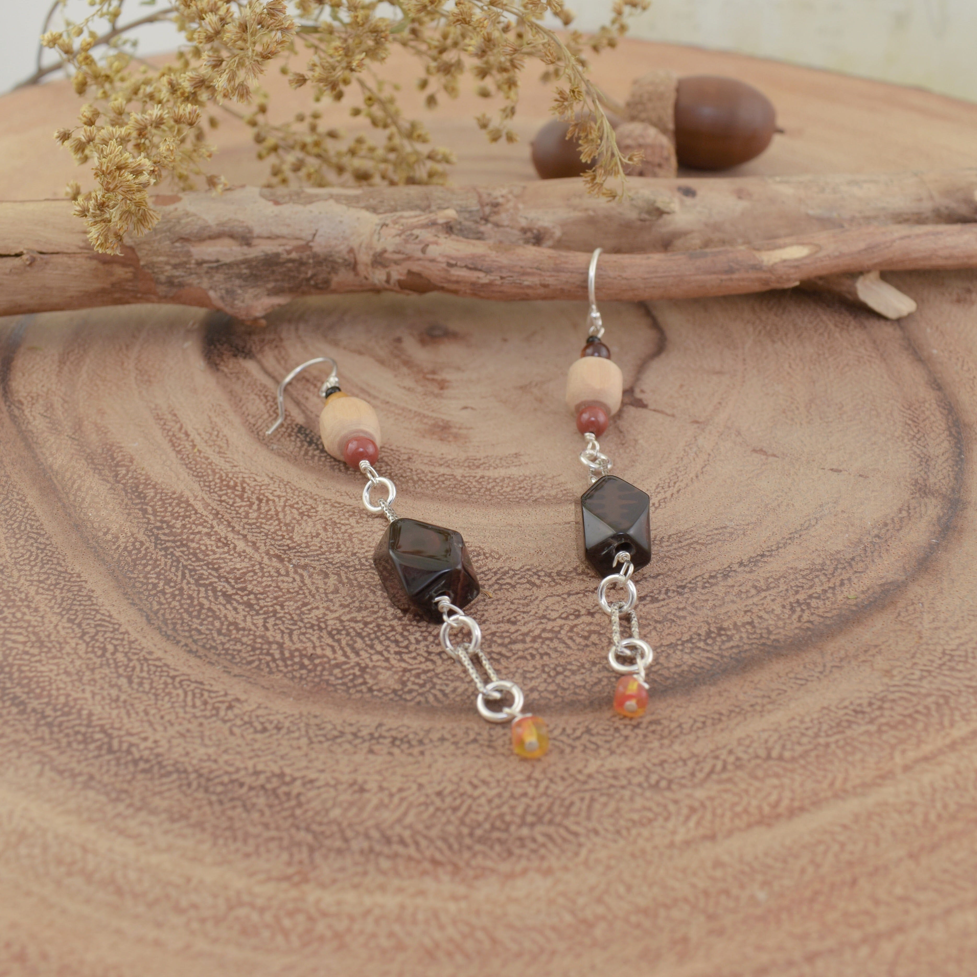 A pair of dangly earrings with sterling silver hooks and multi-colored fall beads