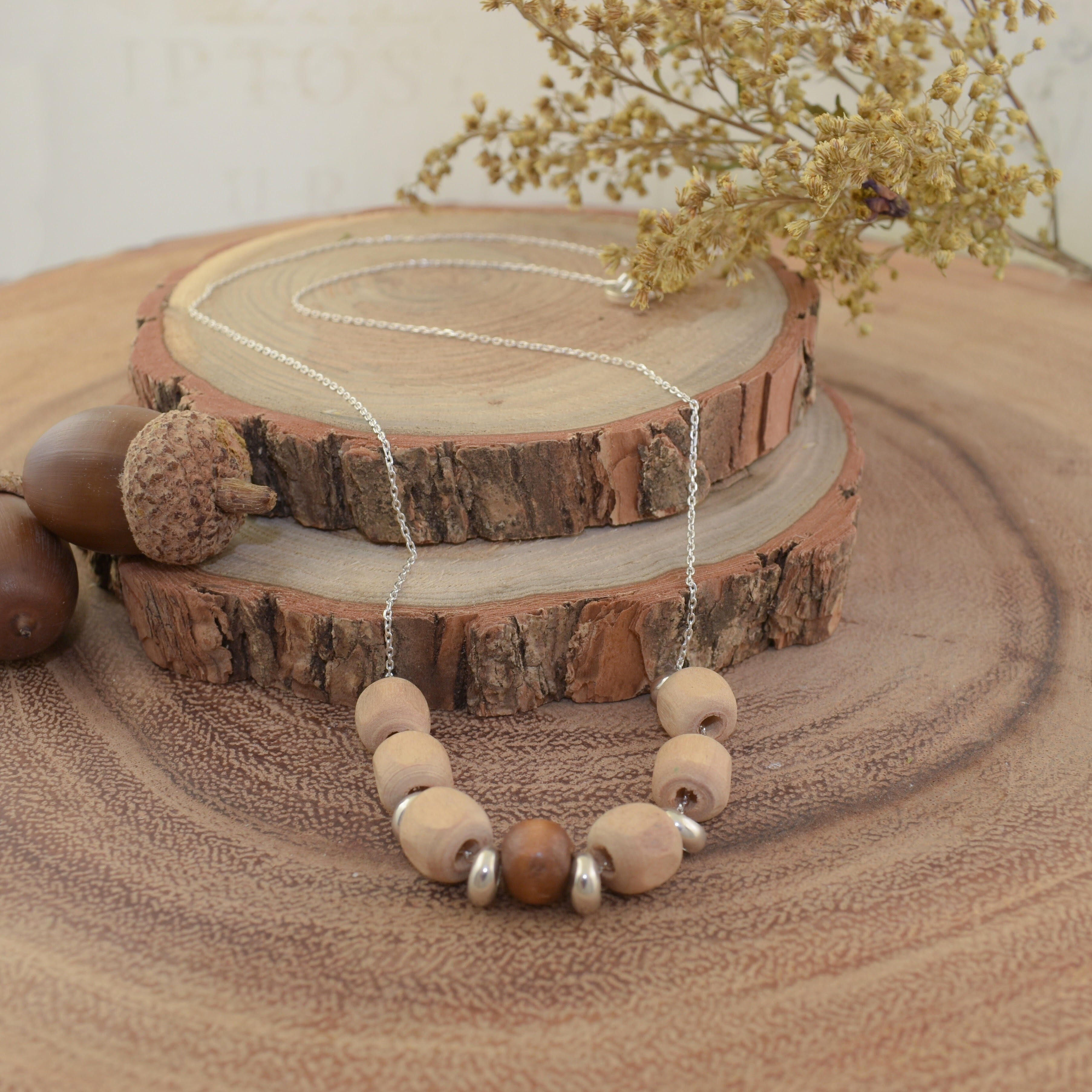 A sterling silver necklace with wooden bead accents and silver spacer beads